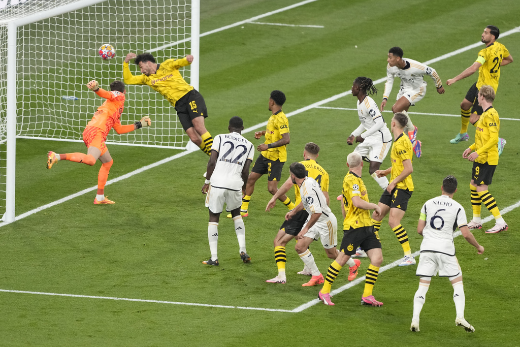 Dortmund's goalkeeper Gregor Kobel, left, fails to save the ball as Real Madrid's Dani Carvajal, center foreground, scores his side's opening goal during the Champions League final soccer match between Borussia Dortmund and Real Madrid at Wembley stadium in London, Saturday, June 1, 2024. (AP Photo/Alastair Grant)