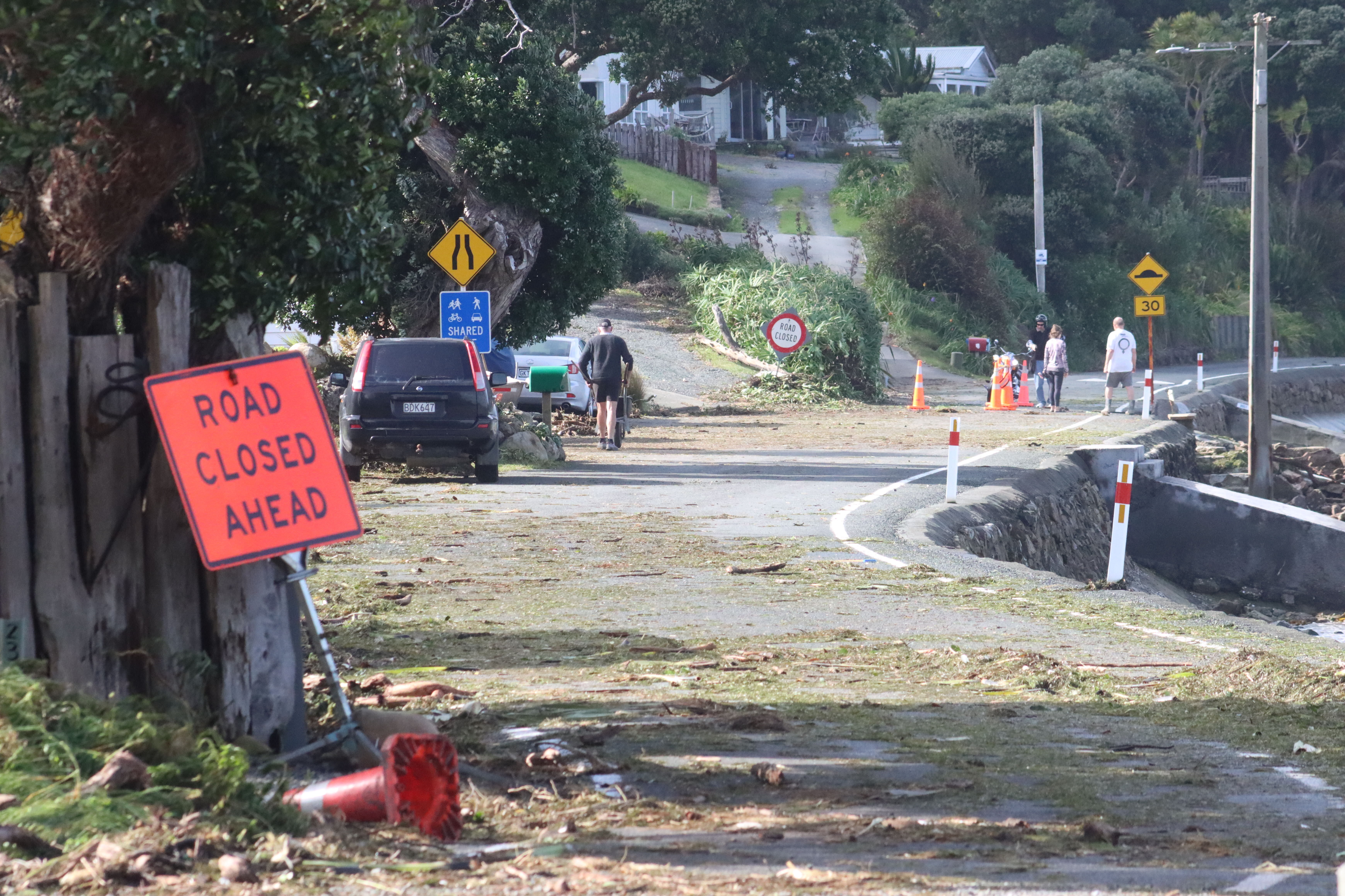 Whangārei Heads residents remove debris from Urquhart Bay Rd. Photo / Karina Cooper