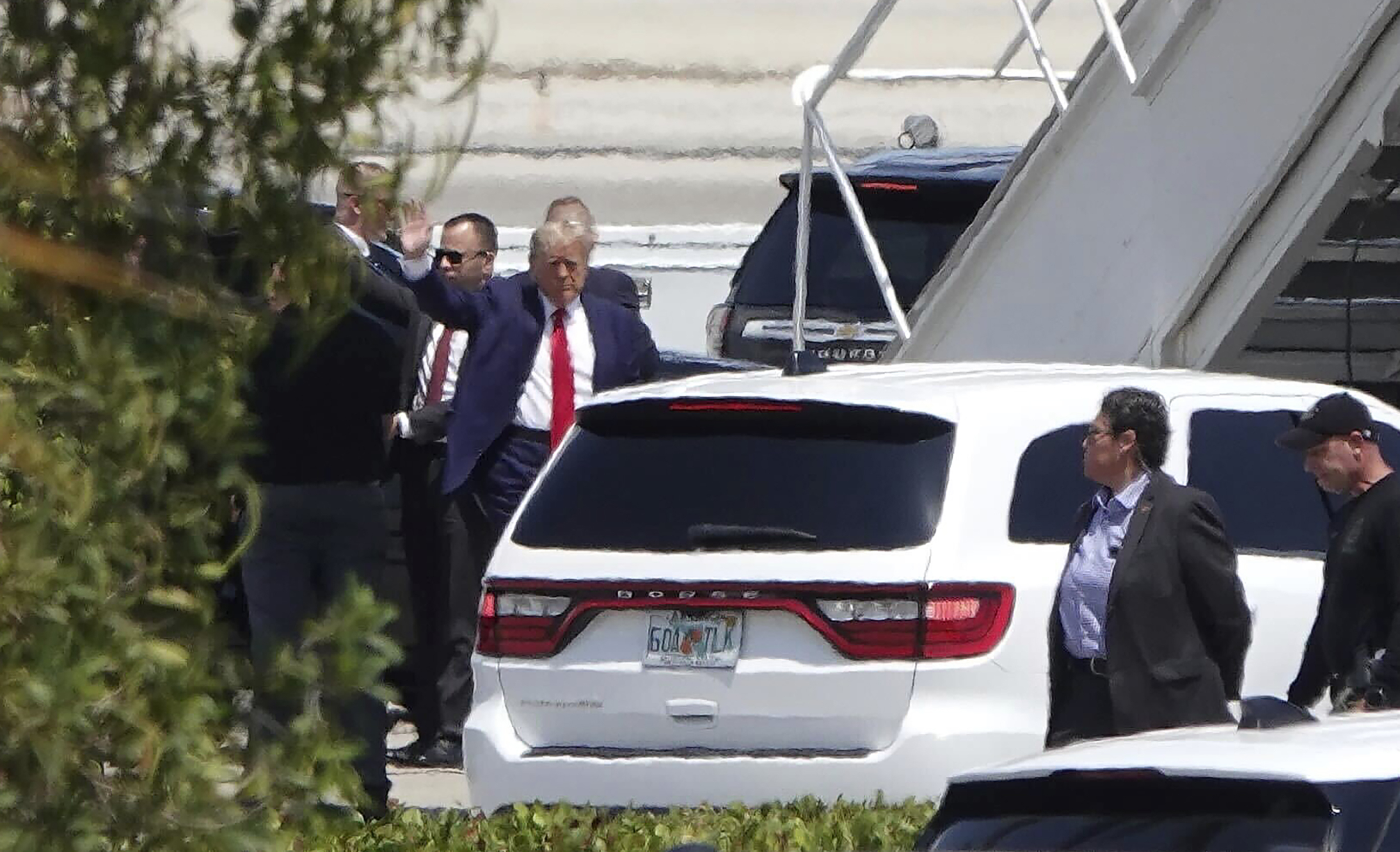 Former president Donald Trump waves before boarding his plane from Florida to New York. Photo / AP