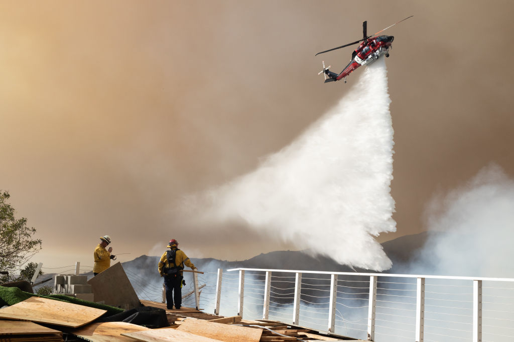 A helicopter drops water on the Palisades fire near the Sullivan Canyon area of Los Angeles on Saturday, local time. Photo / Getty Images