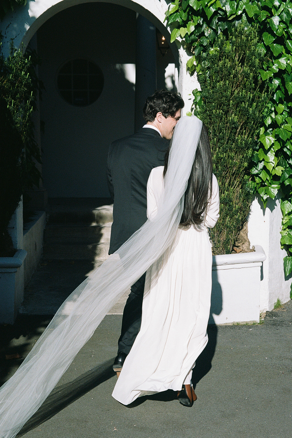 Anna's dress and veil are Ingrid Starnes, and Partick's suit is a tailored piece from David Jones. Photo / Ophelia Mikkelson Jones