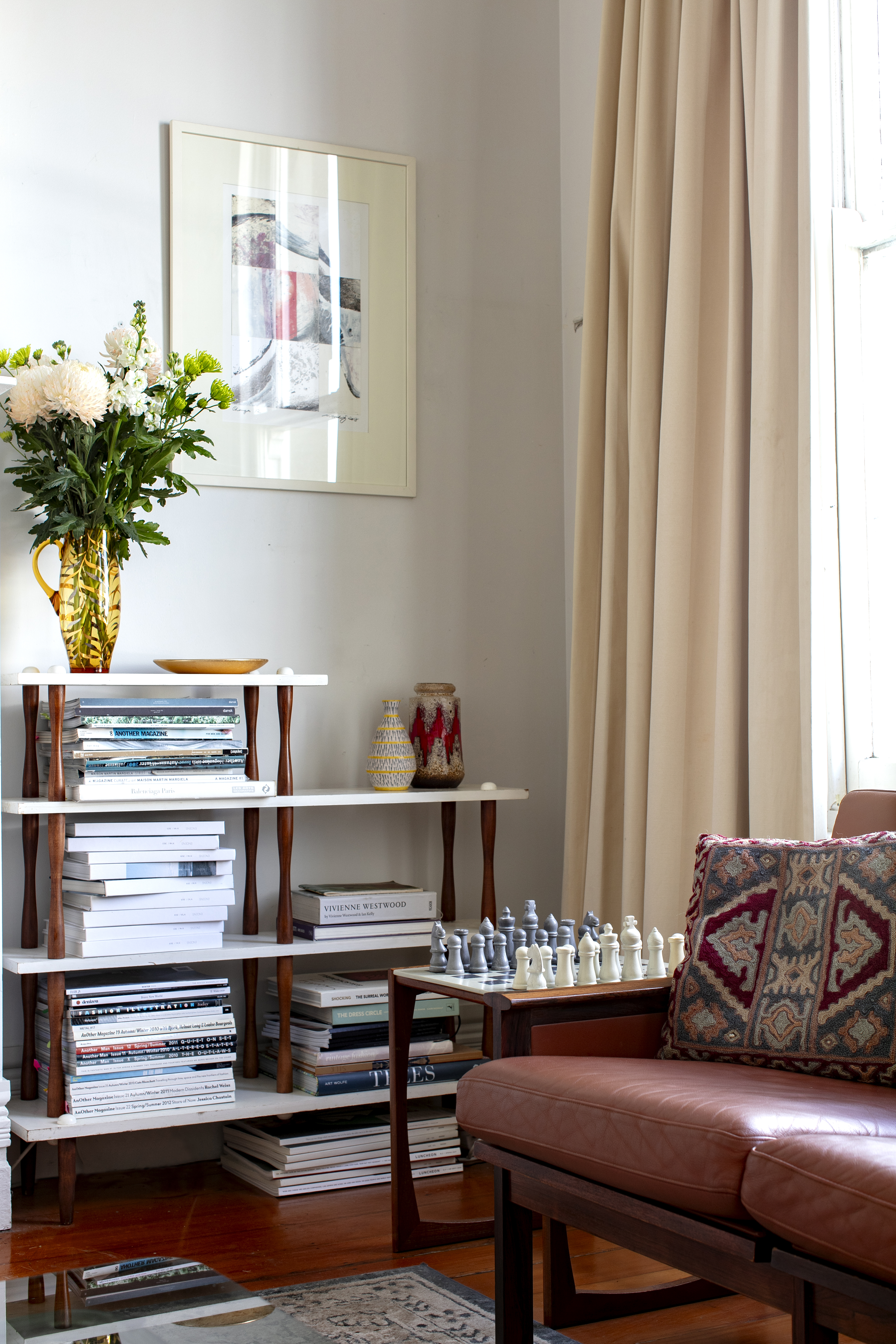 A piece by Rory's dad, 'Changes', 2018, hangs above a collection of magazines and books. Photo / Babiche Martens