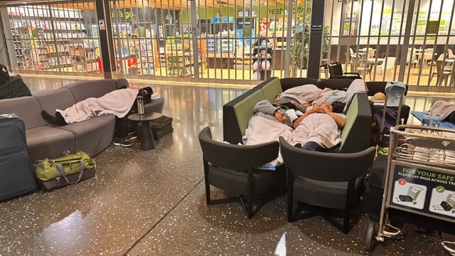 These travellers get creative in making a double bed out of airport furniture. Photo / Supplied