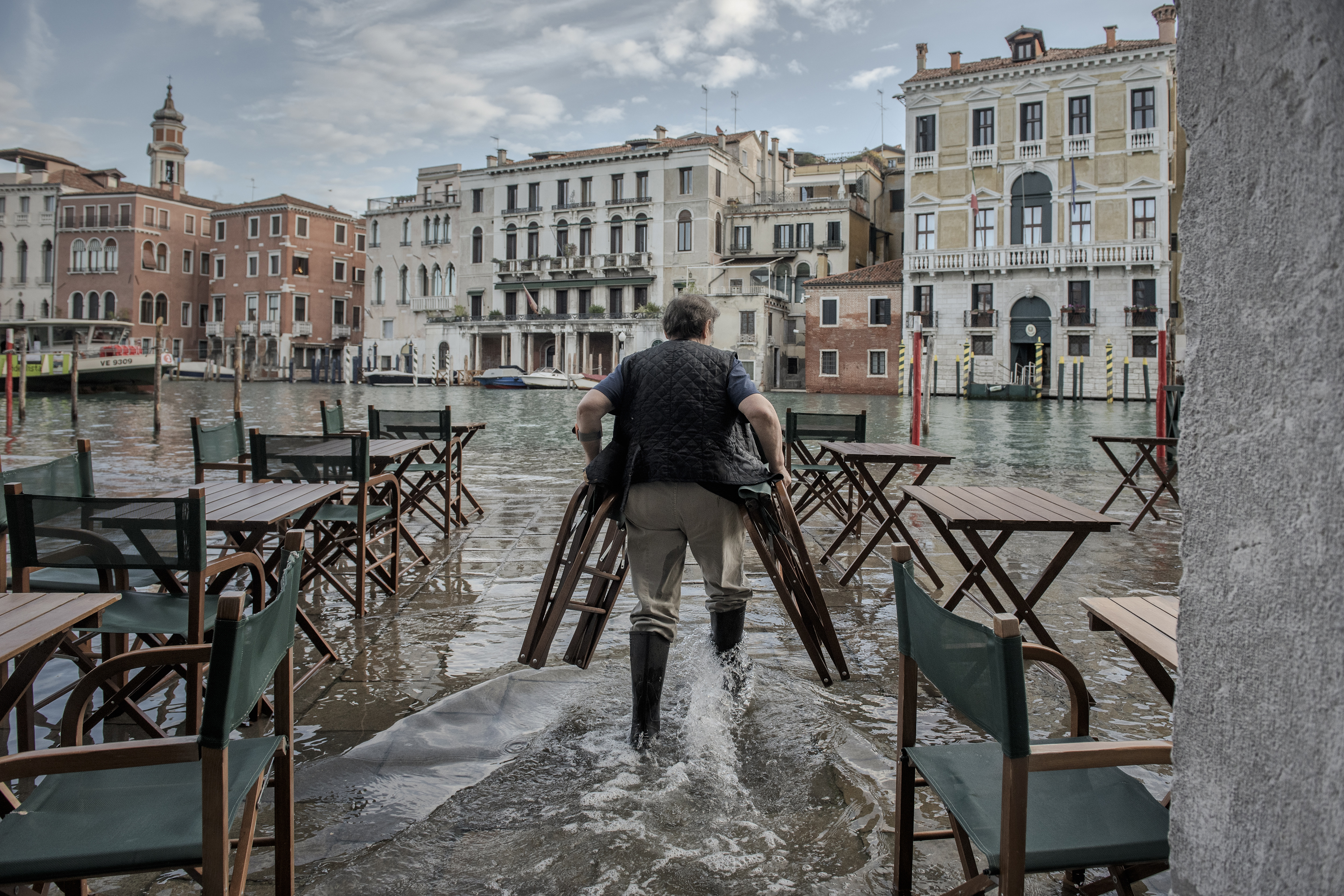 The lowest areas flooded only modestly in November, and this waitress continued preparing tables. Photo / Laetitia Vancon, The New York Times