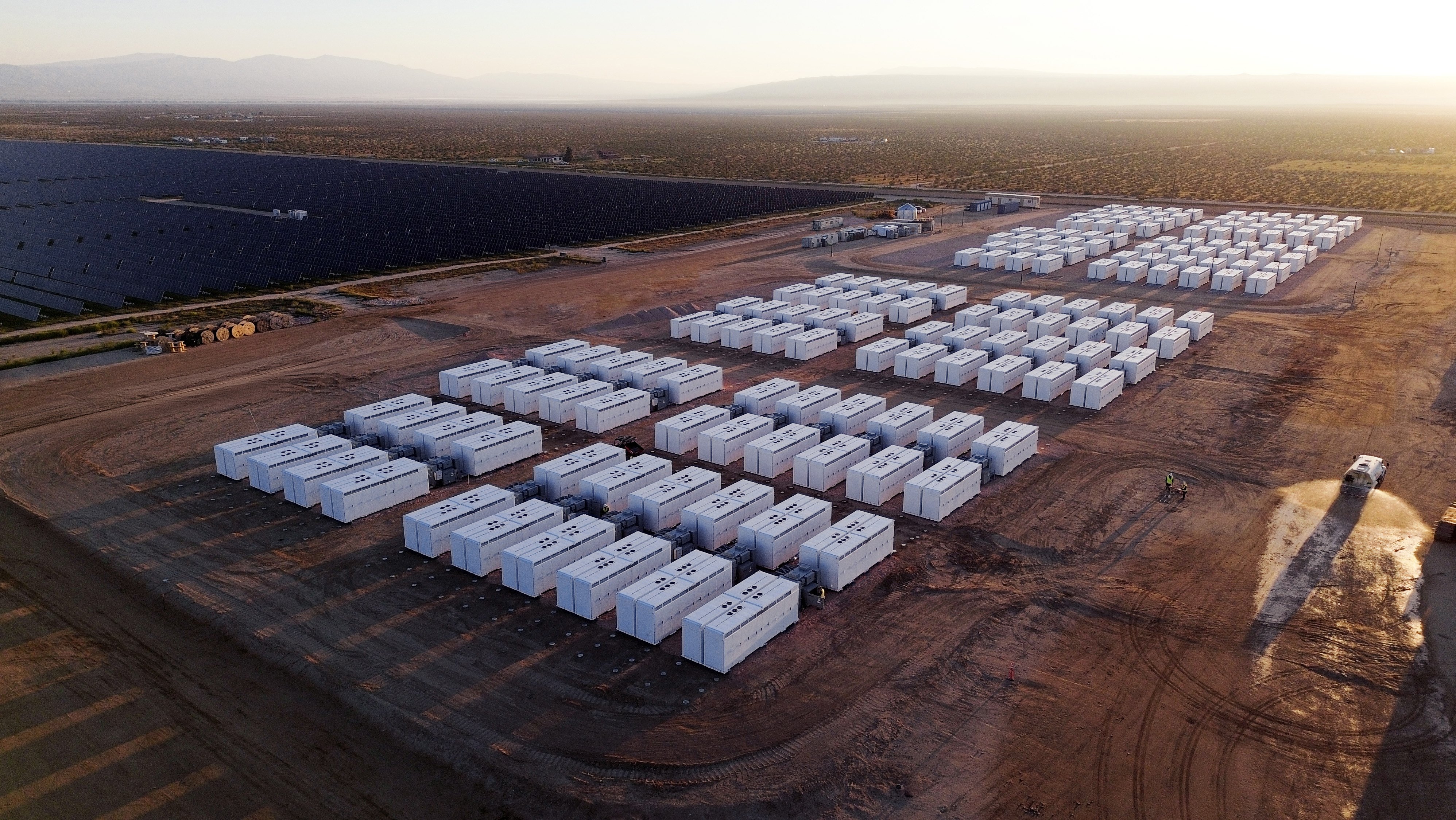 A Tesla Megapack 2 XL battery storage system next to a solar array farm. Photo / Contact Energy