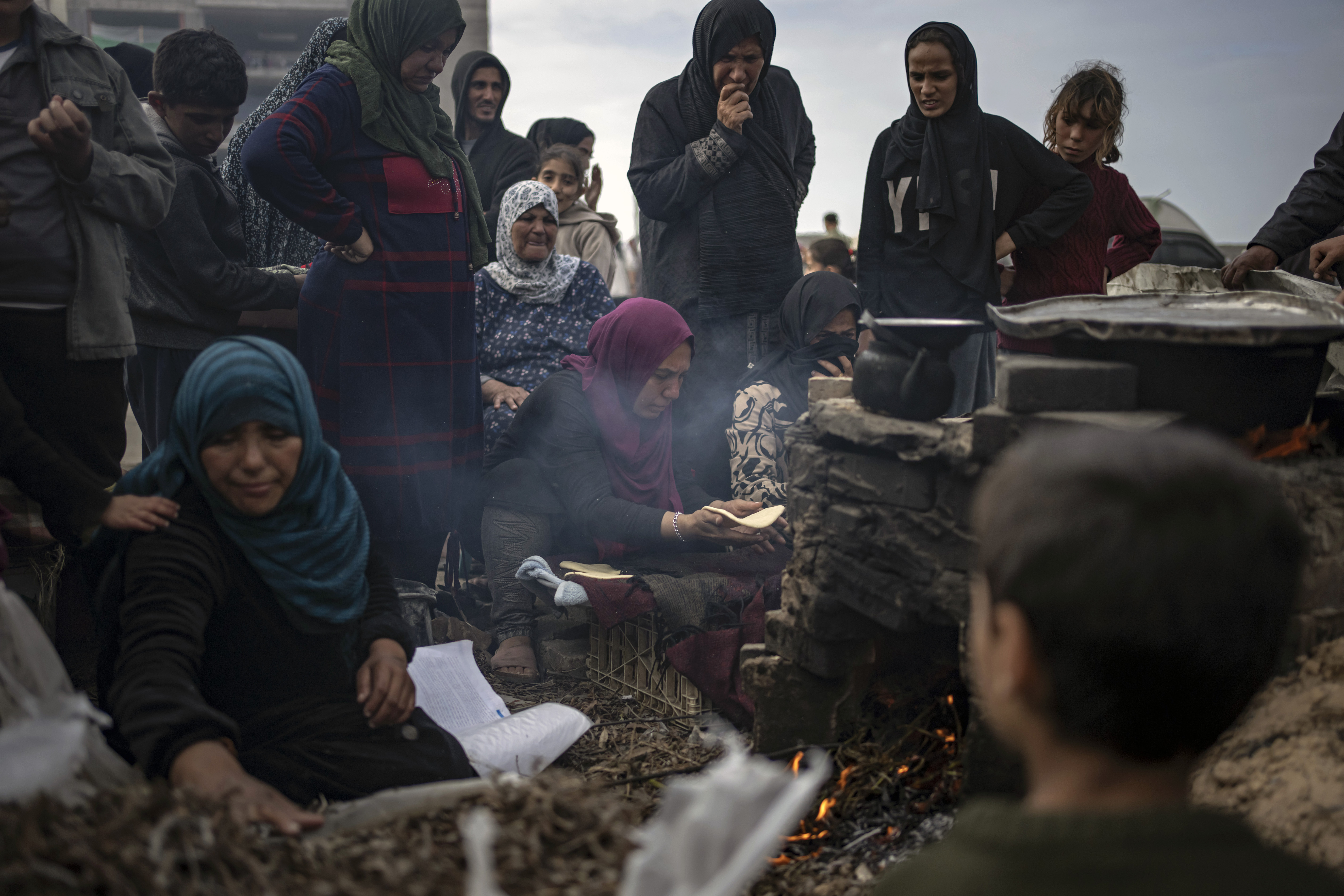 Palestinians displaced by the Israeli bombardment wait for their turn to bake bread at the makeshift tent camp in the Muwasi area in Rafah, Gaza Strip. Photo / AP