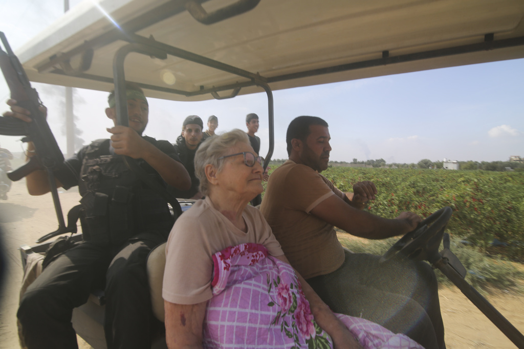 Palestinians transport a captured Israeli civilian, centre, from Kibbutz Kfar Azza into the Gaza Strip. Photo / AP
