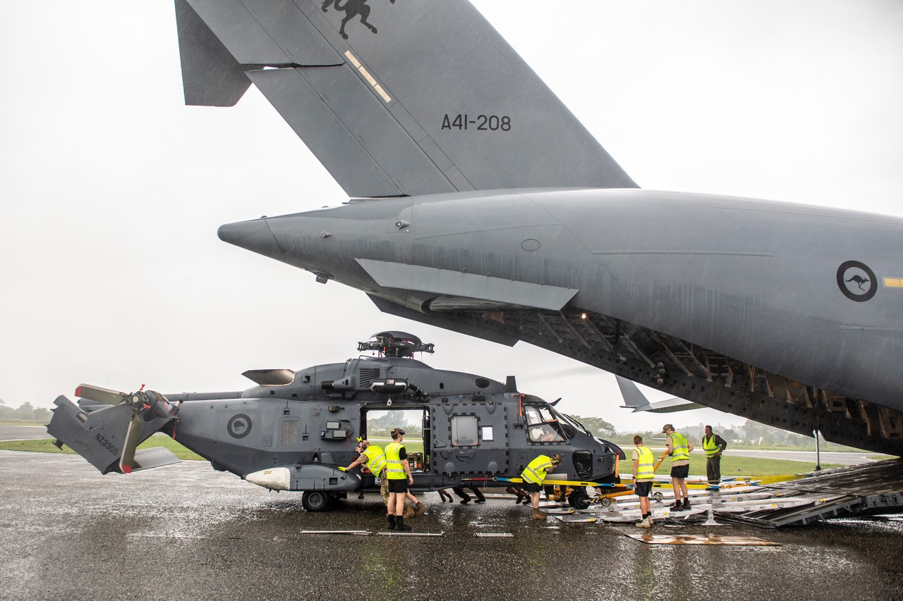 A Royal New Zealand Air Force NH90 helicopter being loaded onto an Australian military transport.