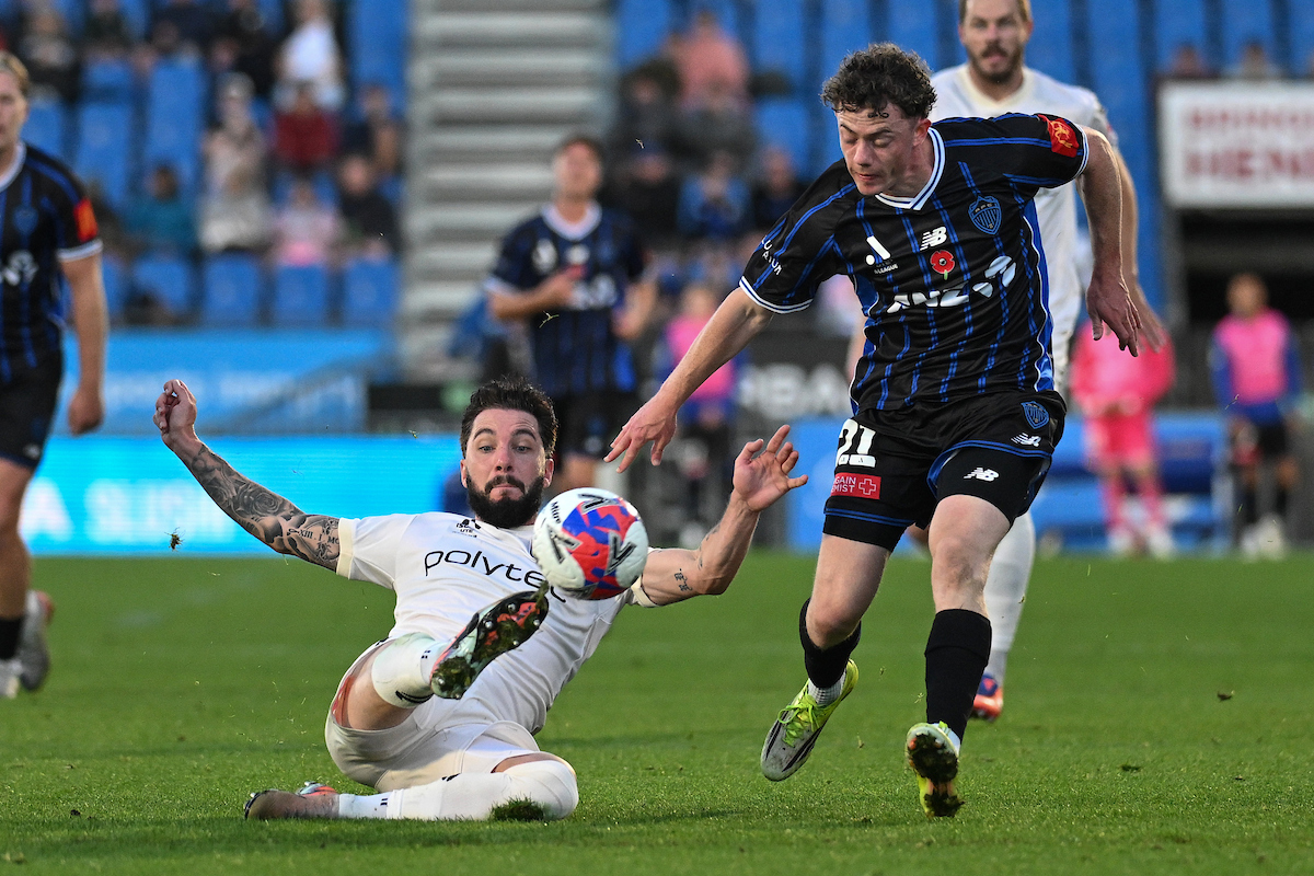 Mariners defender Storm Roux battles with Auckland FC's Jesse Randall for the ball. Photo / Photosport