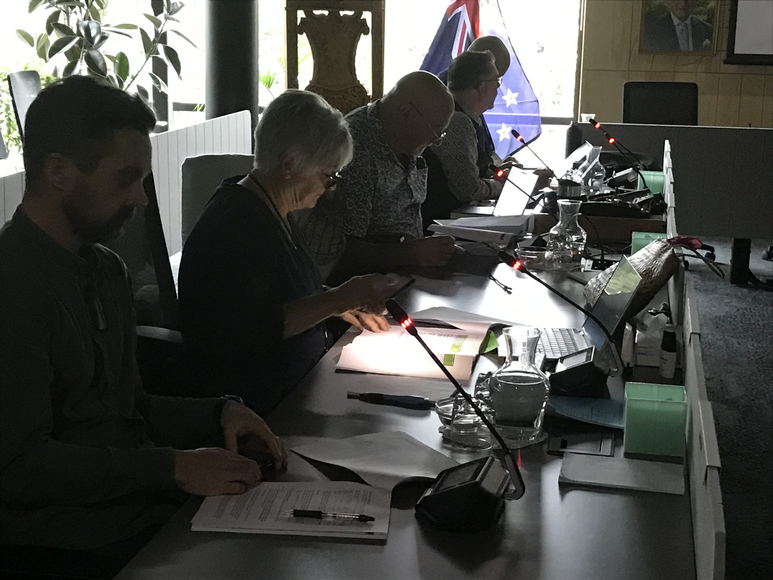 Whangārei District councillor Marie Olsen uses her cell phone for lighting after this morning's power cut plunged Te Iwitahi council chambers into near darkness. Photo / Susan Botting / LDR