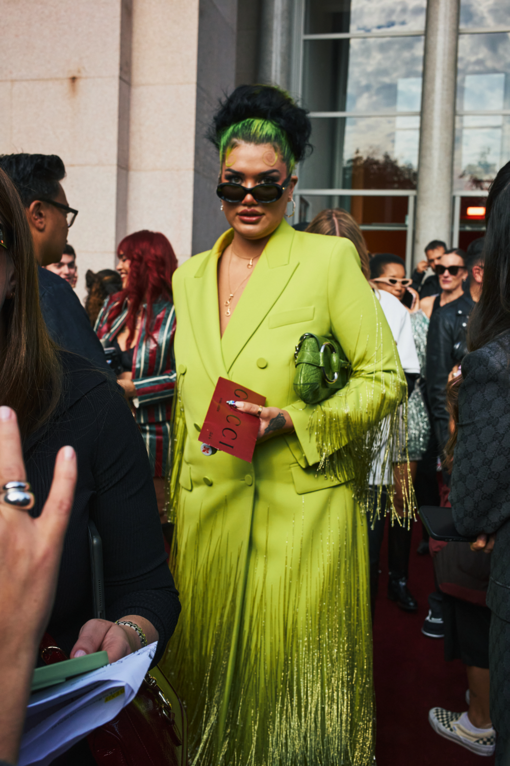 Sparkly fringe trimming brought a theatrical quality to this brat-green attire. Photo / Simbarashe Cha for The New York Times