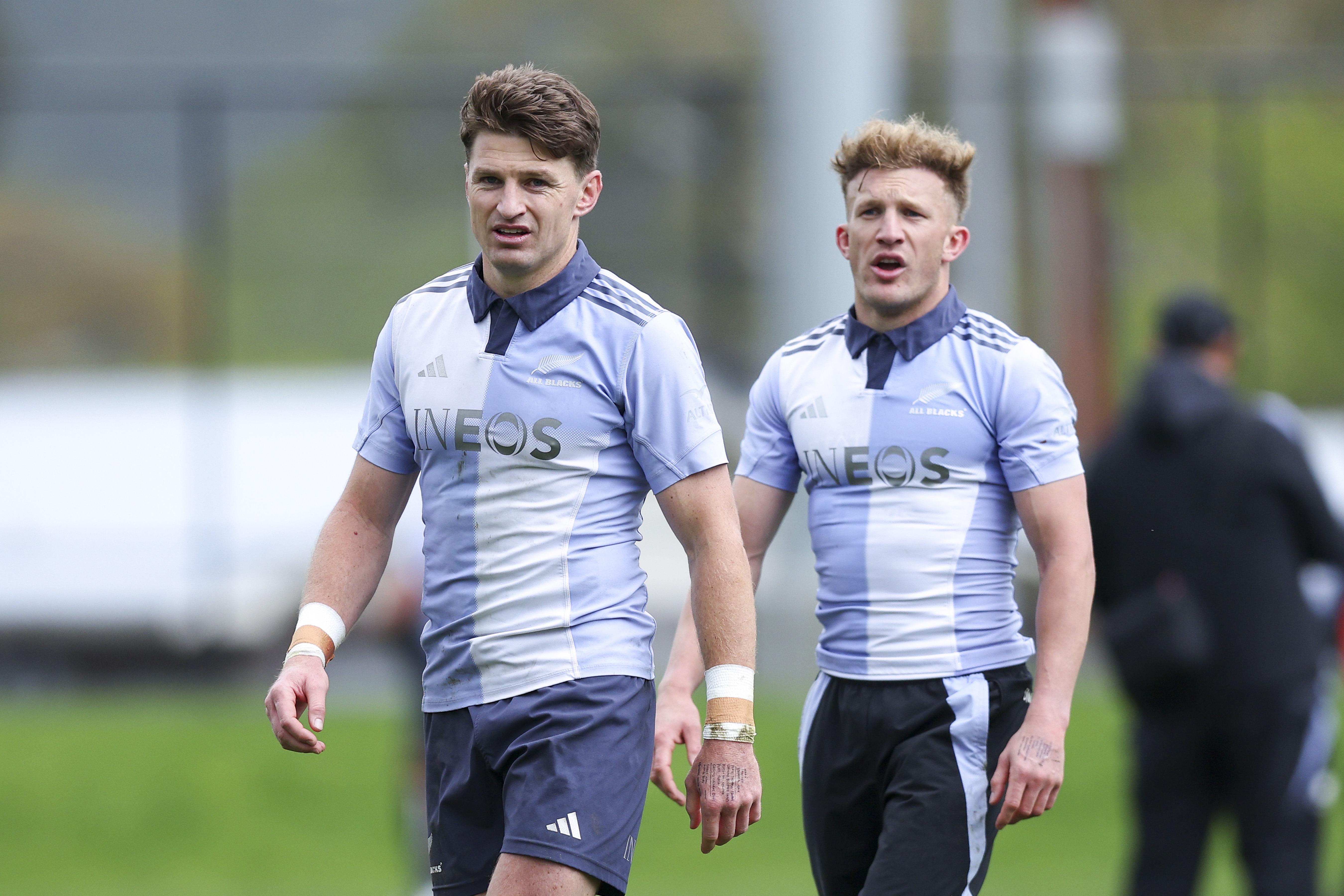 Beauden Barrett (left) and Damian McKenzie (right) look on during an All Blacks training session in Wellington. Photo / Getty Images