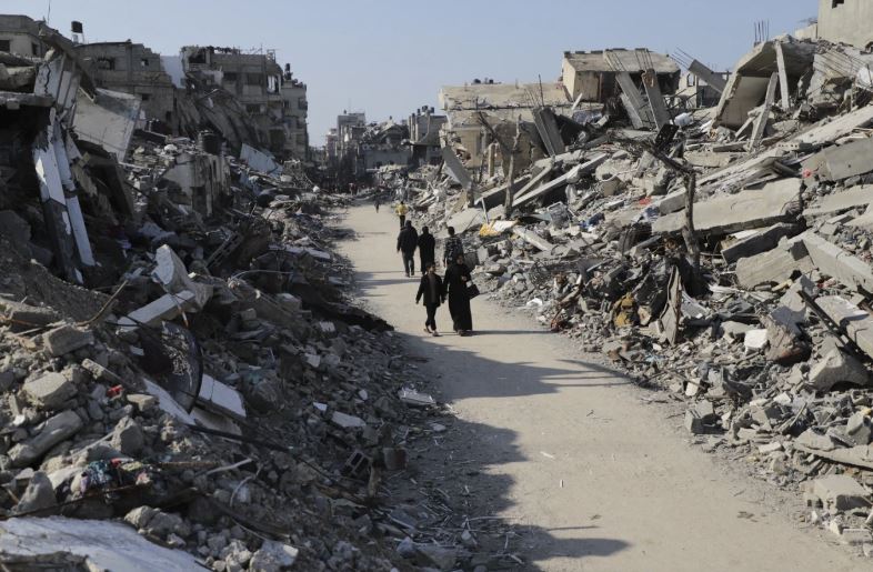 Palestinians walk through the destruction from the Israeli offensive in Jabaliya refugee camp in the Gaza Strip. Photo / AP