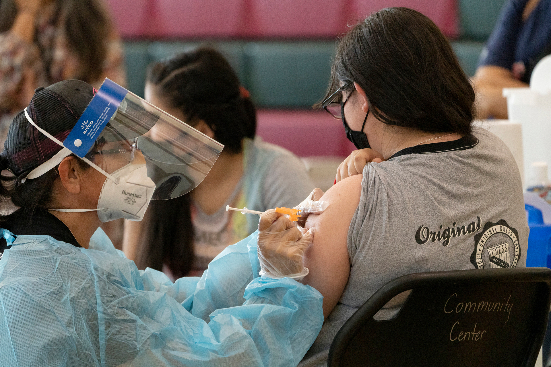 Sisters Guadalupe Flores, 15, right, and Estela Flores, 13, left, from East Los Angeles, get vaccinated with Pfizer's Covid-19 vaccine. Photo / AP