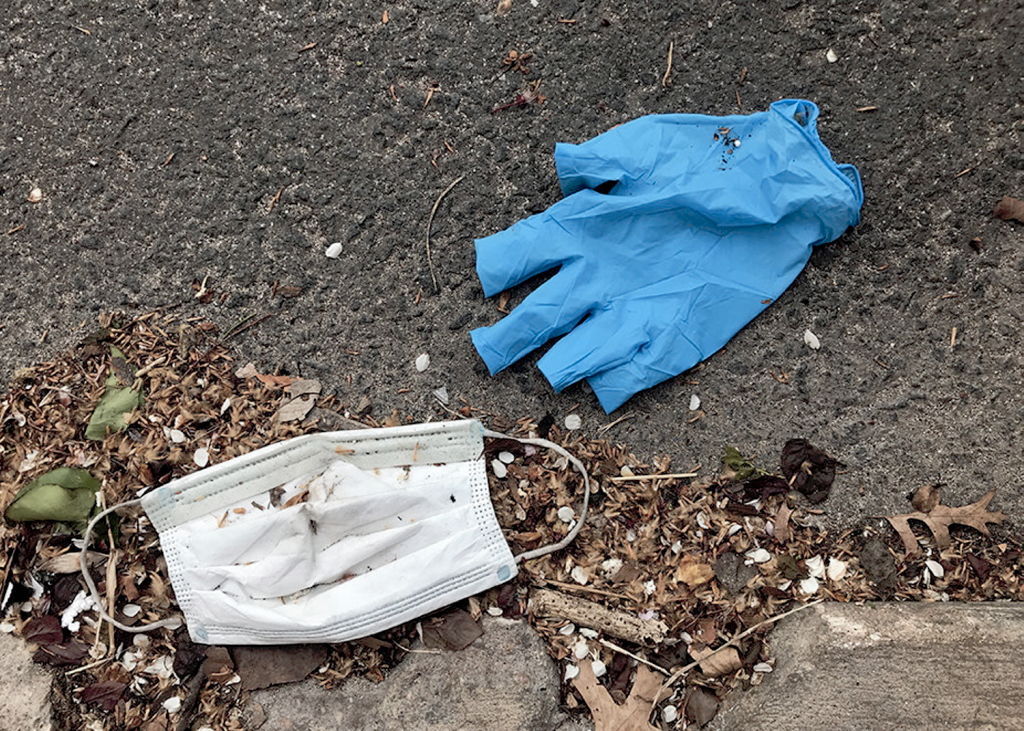 PPE gloves and surgical masks improperly disposed of on the footpath. Photo / Getty Images