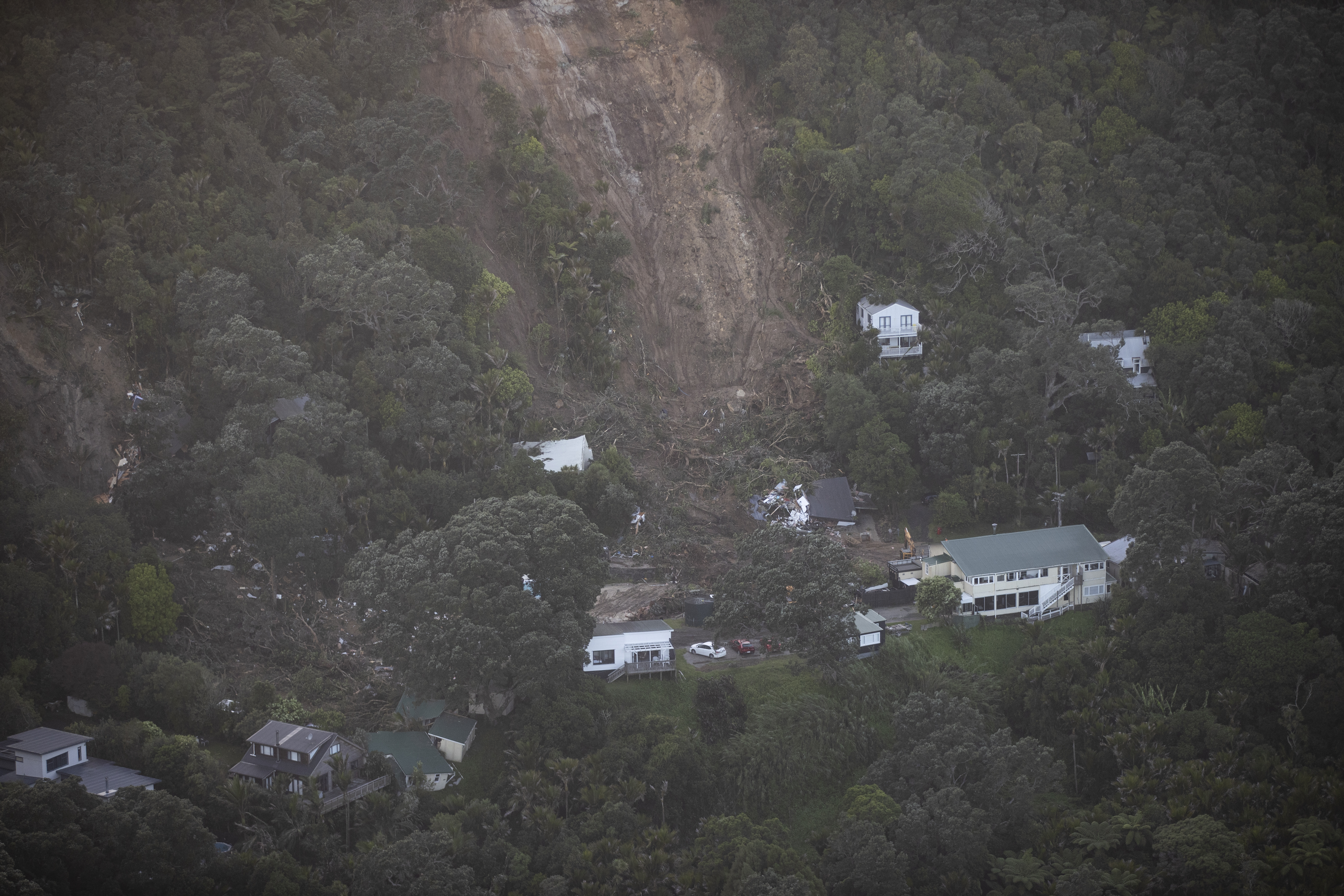 A wider aerial view of the damage caused by a landslip at Muriwai. Photo / George Heard
