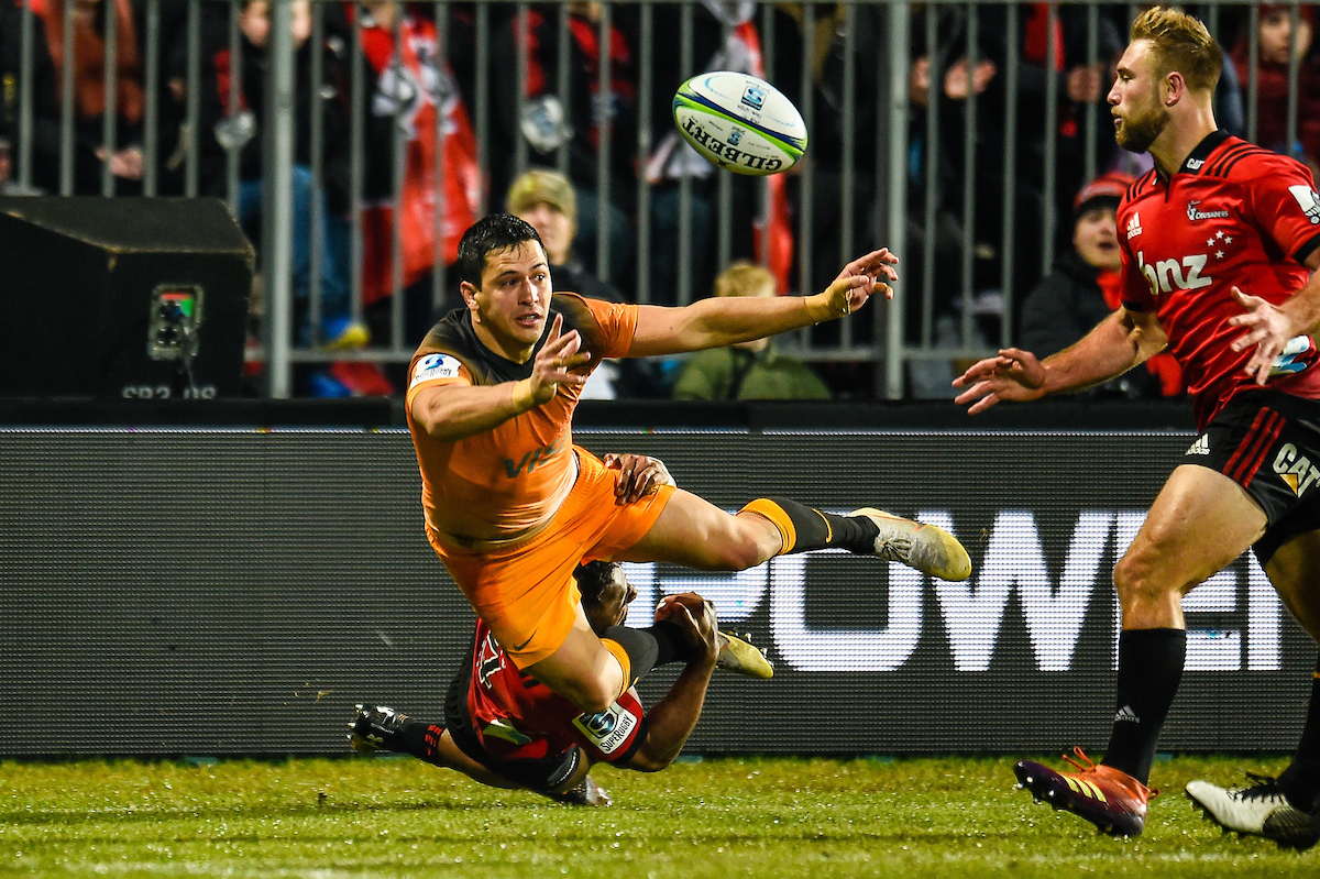 Matias Moroni of the Jaguares offloads in the tackle of George Bridge. Photosport