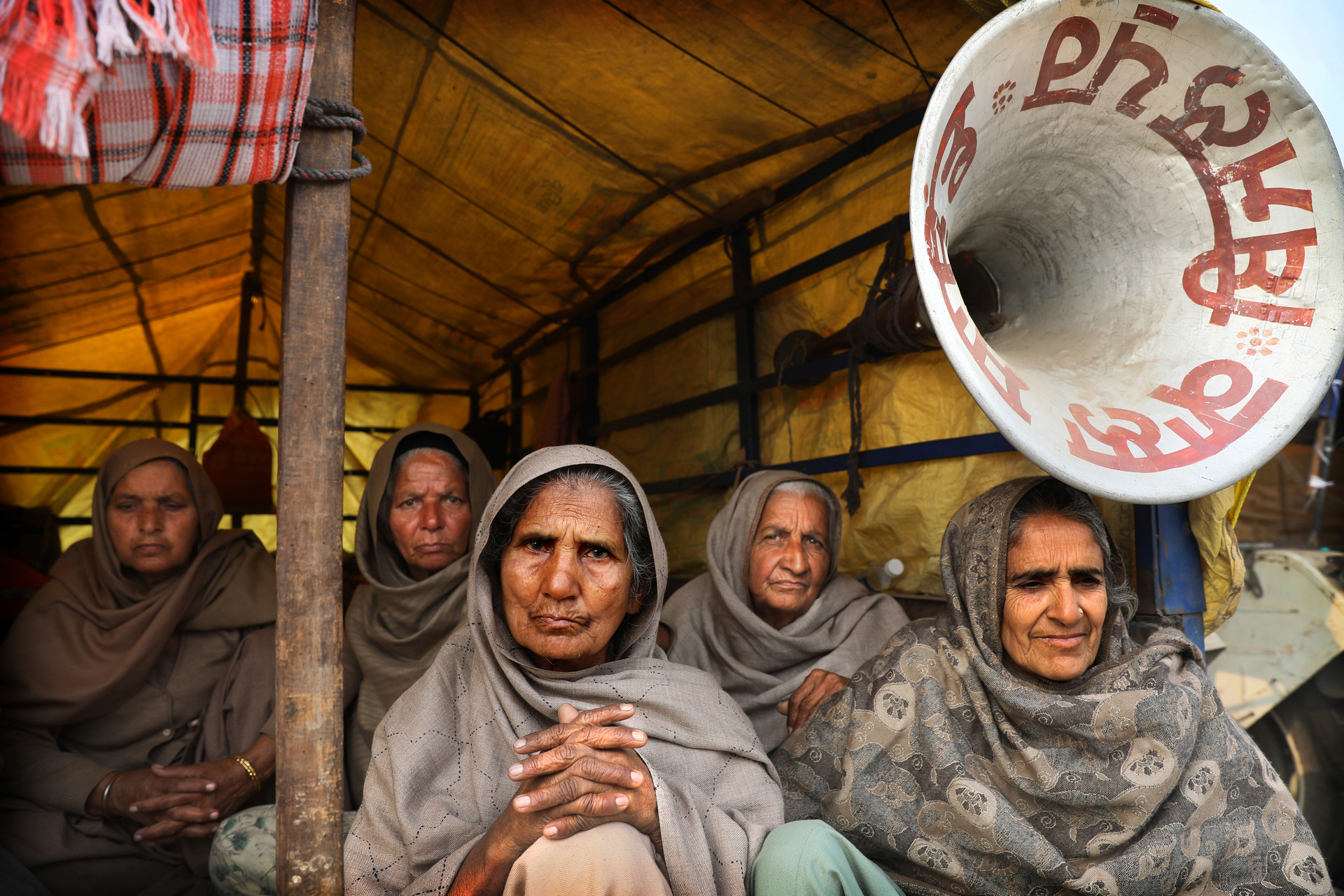 Farmers sit in the back of a trailer as they participate in a protest against new farm laws which will make them poorer. Photo / AP
