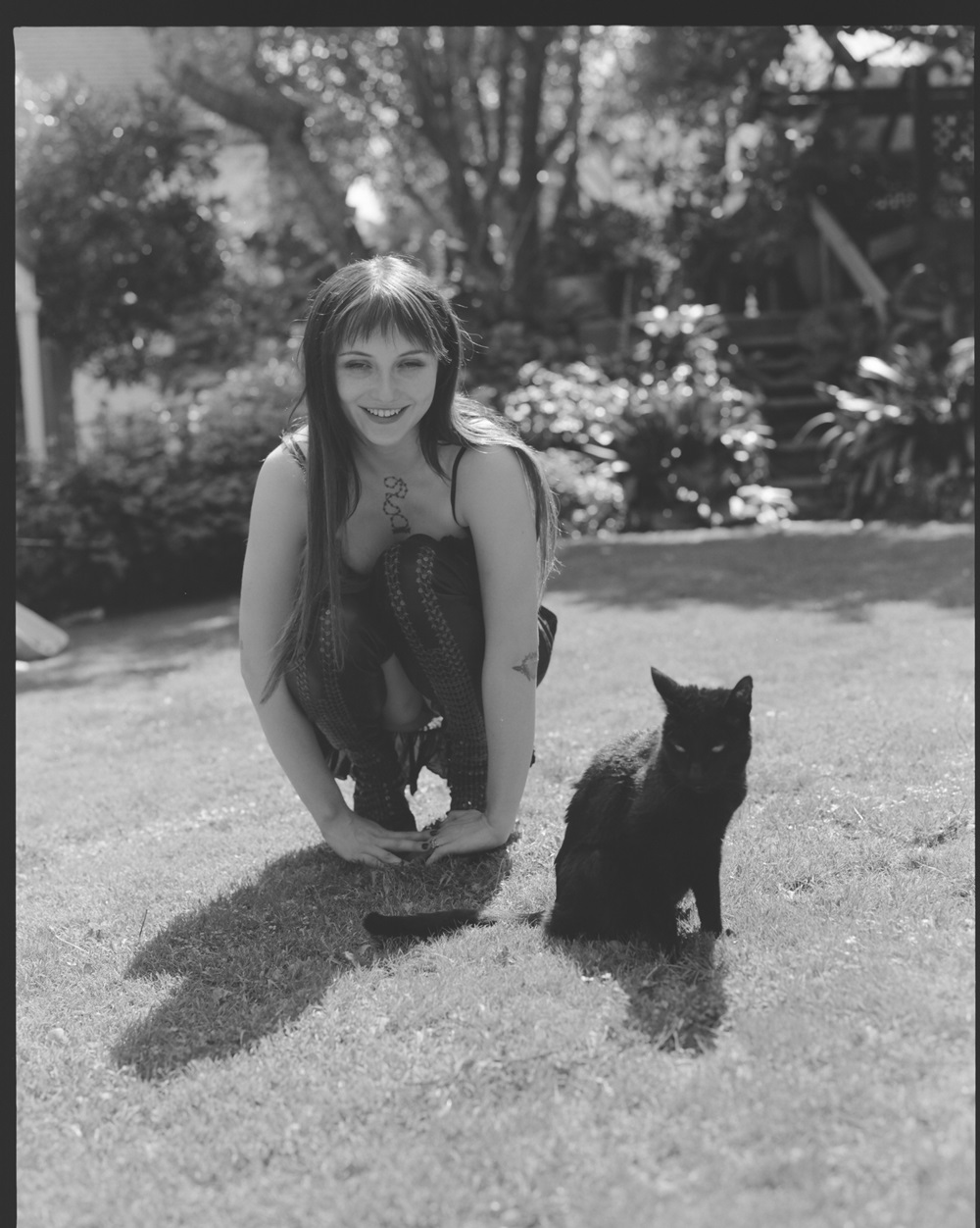 Franca Chase, wearing a second-hand Dolce & Gabbana dress and Rick Owens boots, with her cat Ebony.