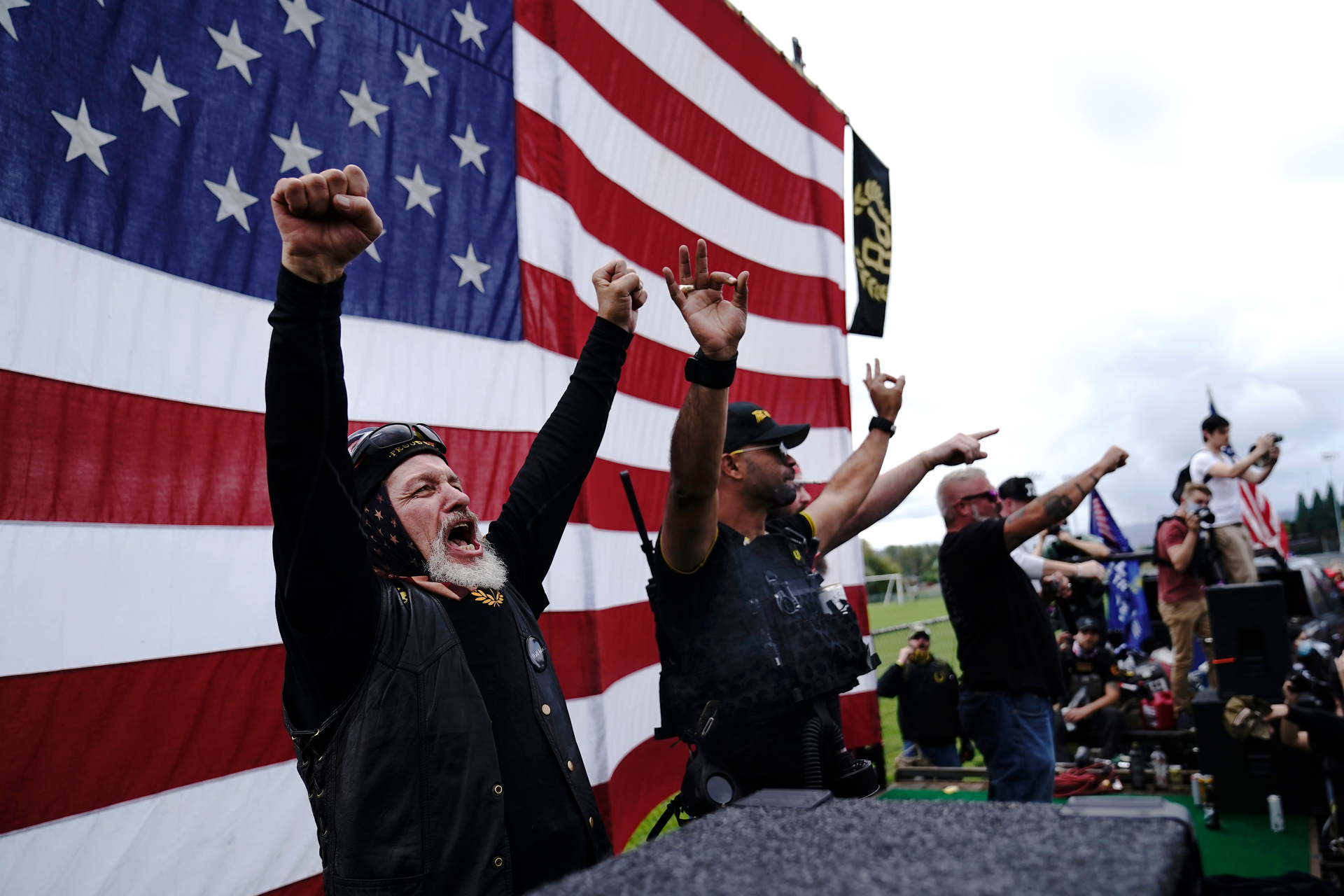 Members of the Proud Boys, including leader Enrique Tarrio, second from left, gesture and cheer on stage as they and other right-wing demonstrators rally in Portland. Photo / AP