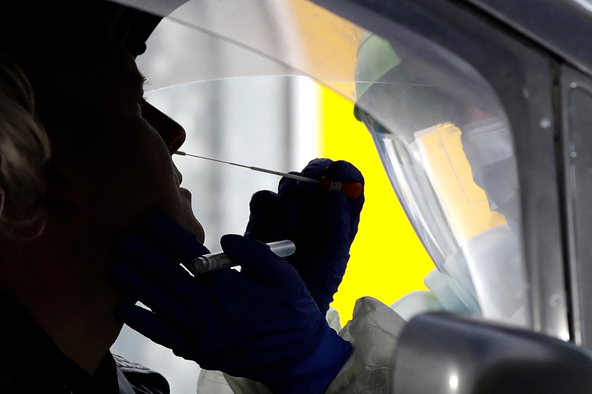 Medical staff test a shopper in his car who volunteered at a pop-up community Covid-19 testing station at a supermarket carpark in Christchurch. Photo / AP