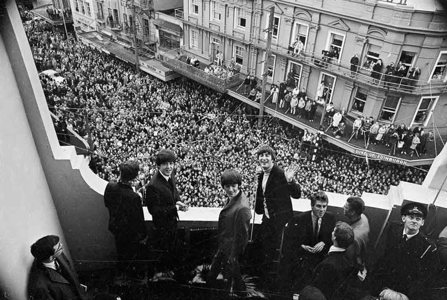 The Beatles on the balcony of the St George Hotel on Willis St, Wellington. Photo / Alexander Turnbull Library