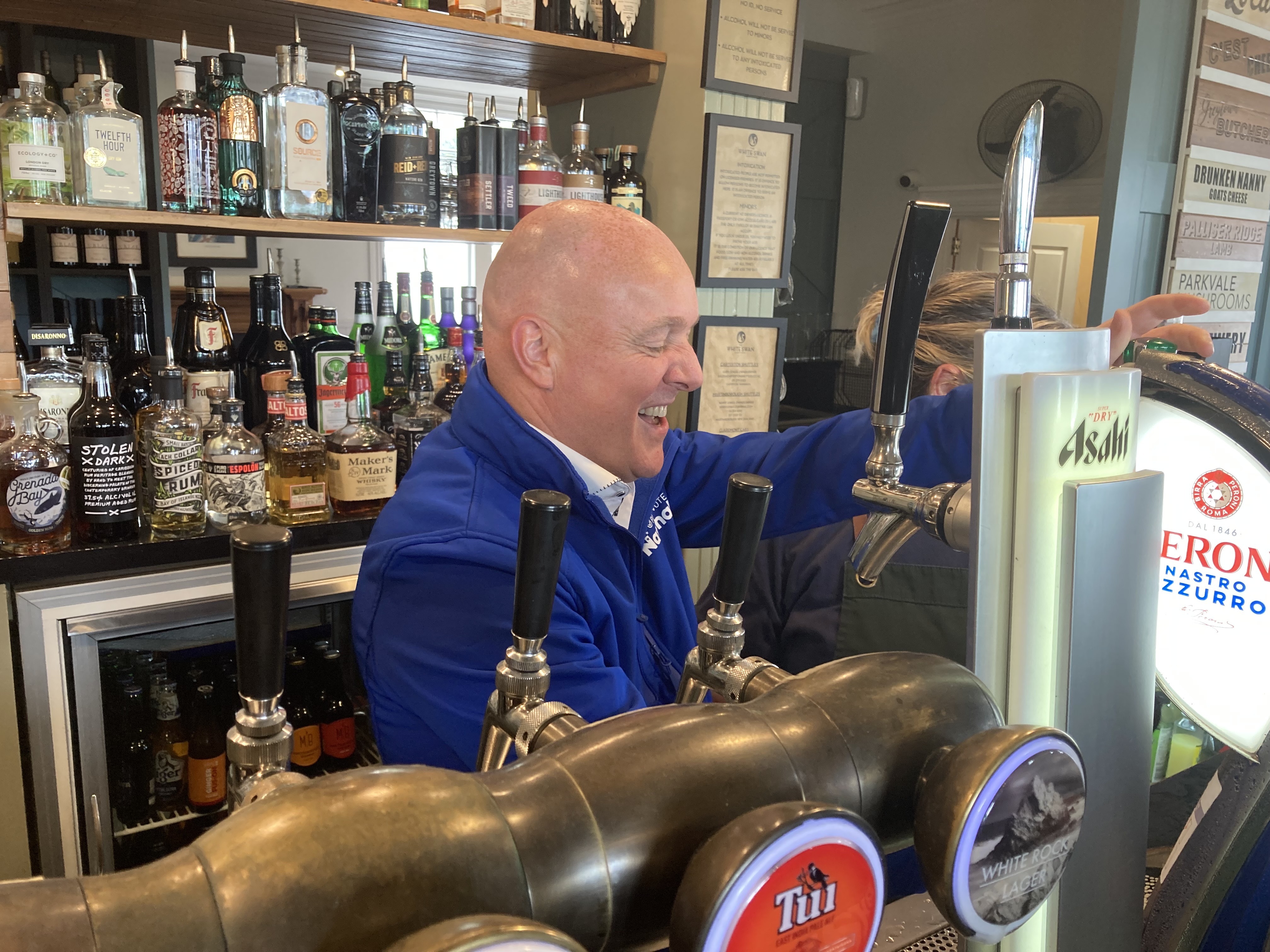 National Party leader Christopher Luxon tries his hand pulling a pint at the White Swan Country Hotel in Greytown. Photo / Claire Trevett 