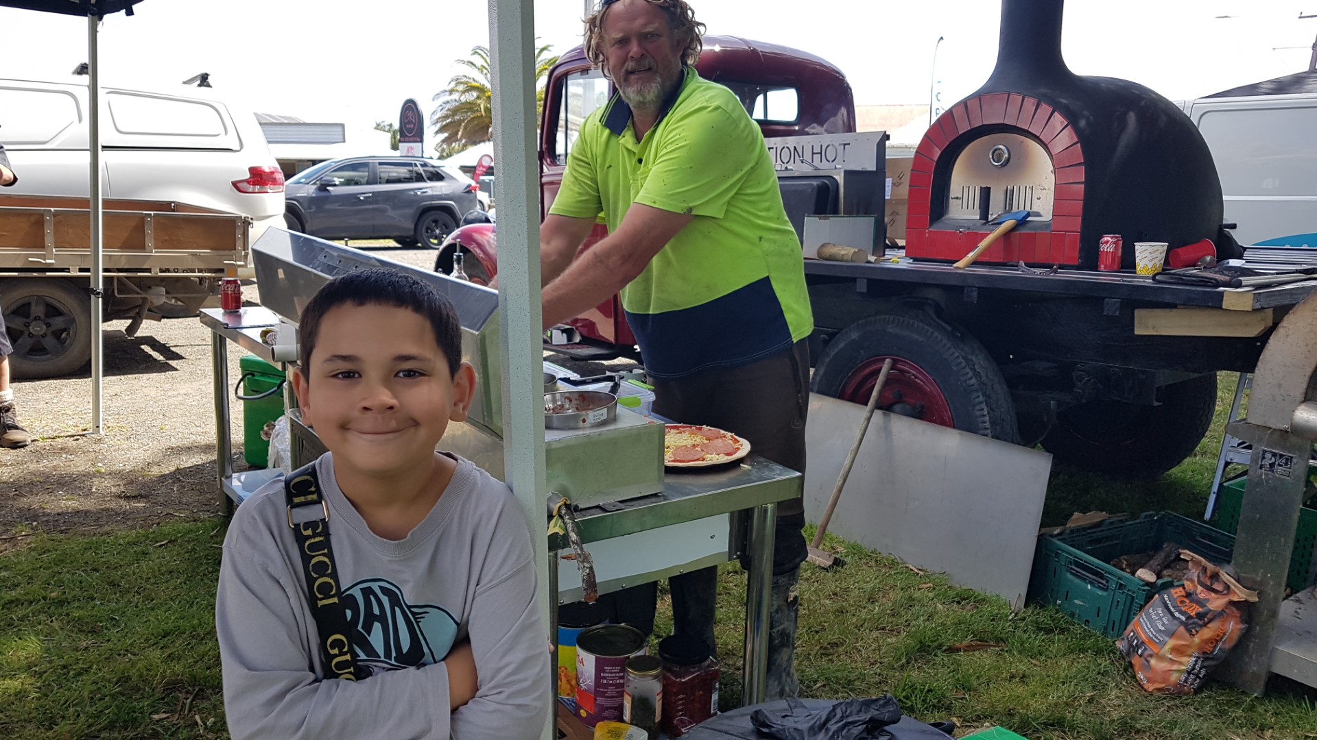 Frederick Marriott, aged 8, waits patiently for Stuart Paterson, from Hillbilly PIzzas, to prepare his meat lovers at Awanui Day