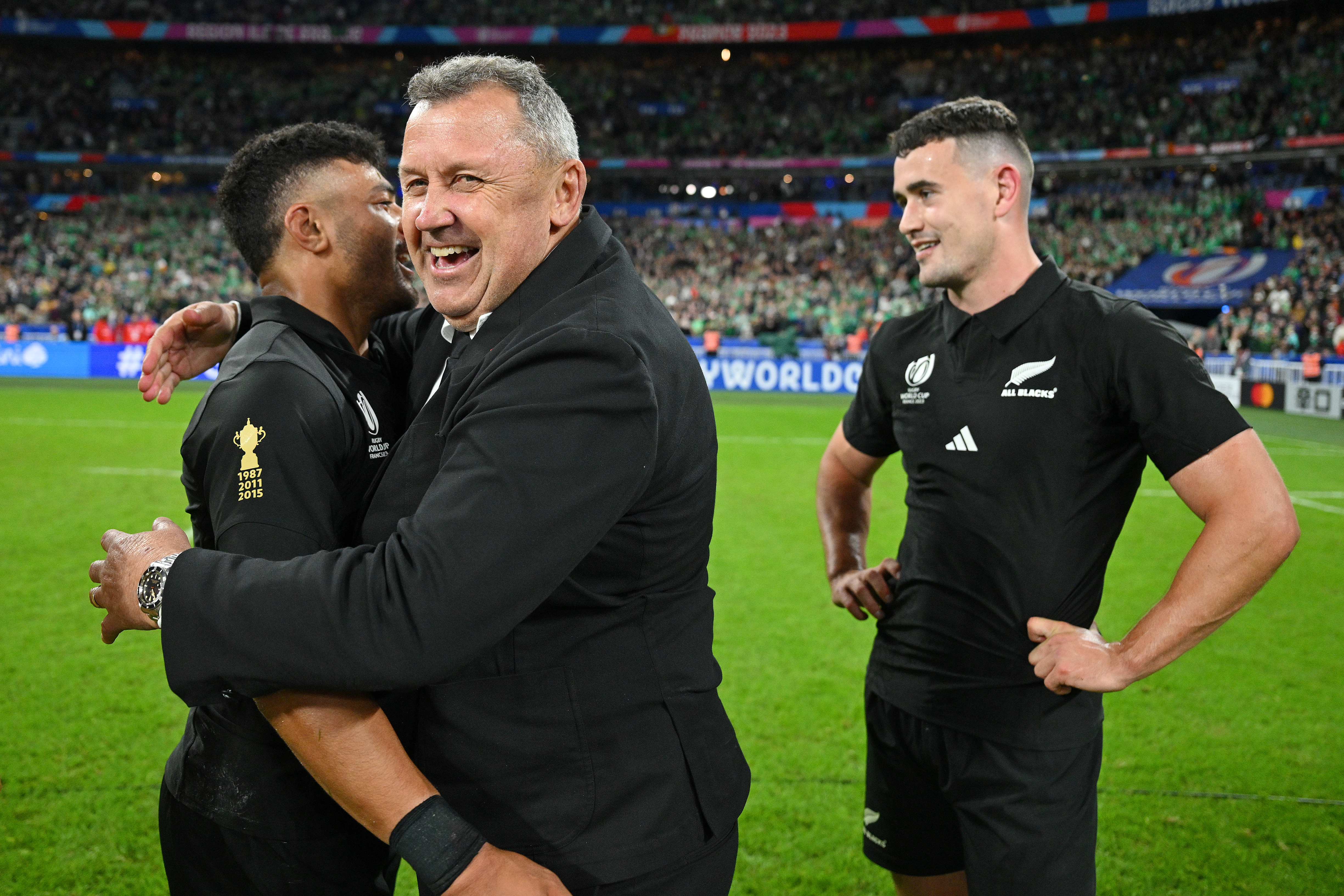 Foster embraces Richie Mo'unga, watched by Will Jordan, after the quarter-final victory over Ireland. Photo / Getty Images