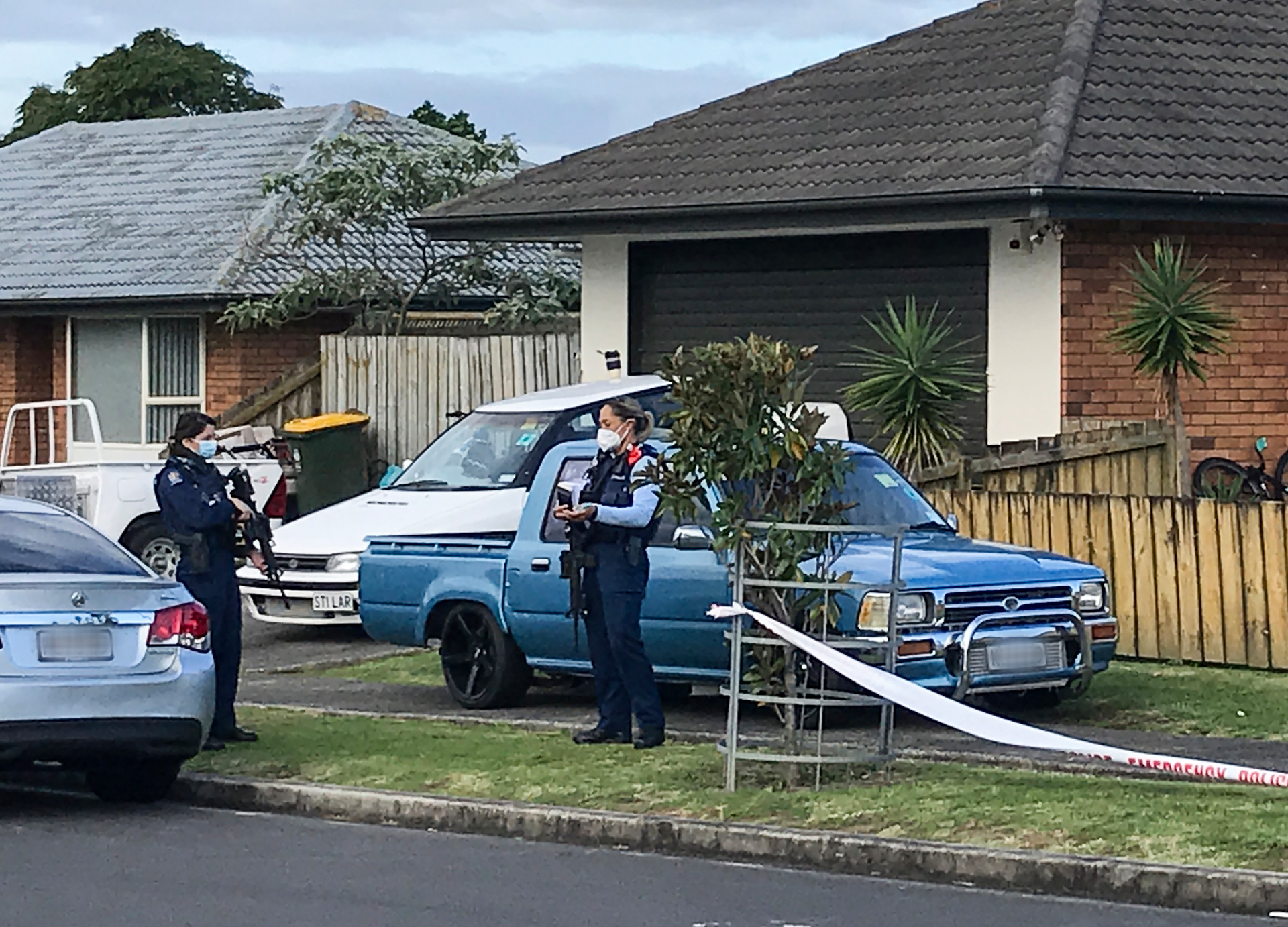 Armed police outside a house in Glen Osborne Terrace, Flat Bush, after a drive-by shooting. Photo / Tom Dillane