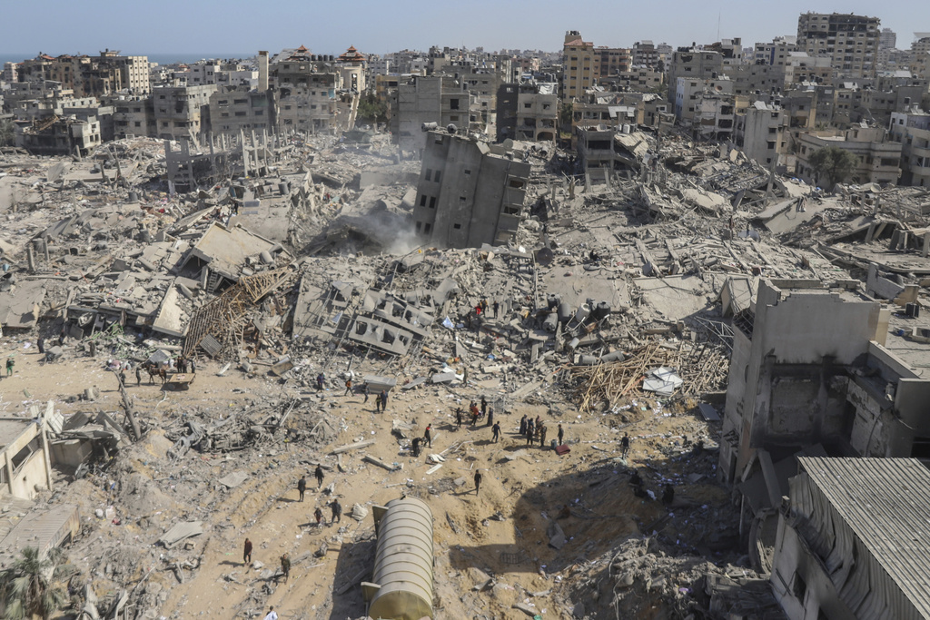Palestinians walk through the destruction left by the Israeli air and ground offensive on Shifa Hospital in Gaza City. Photo / AP
