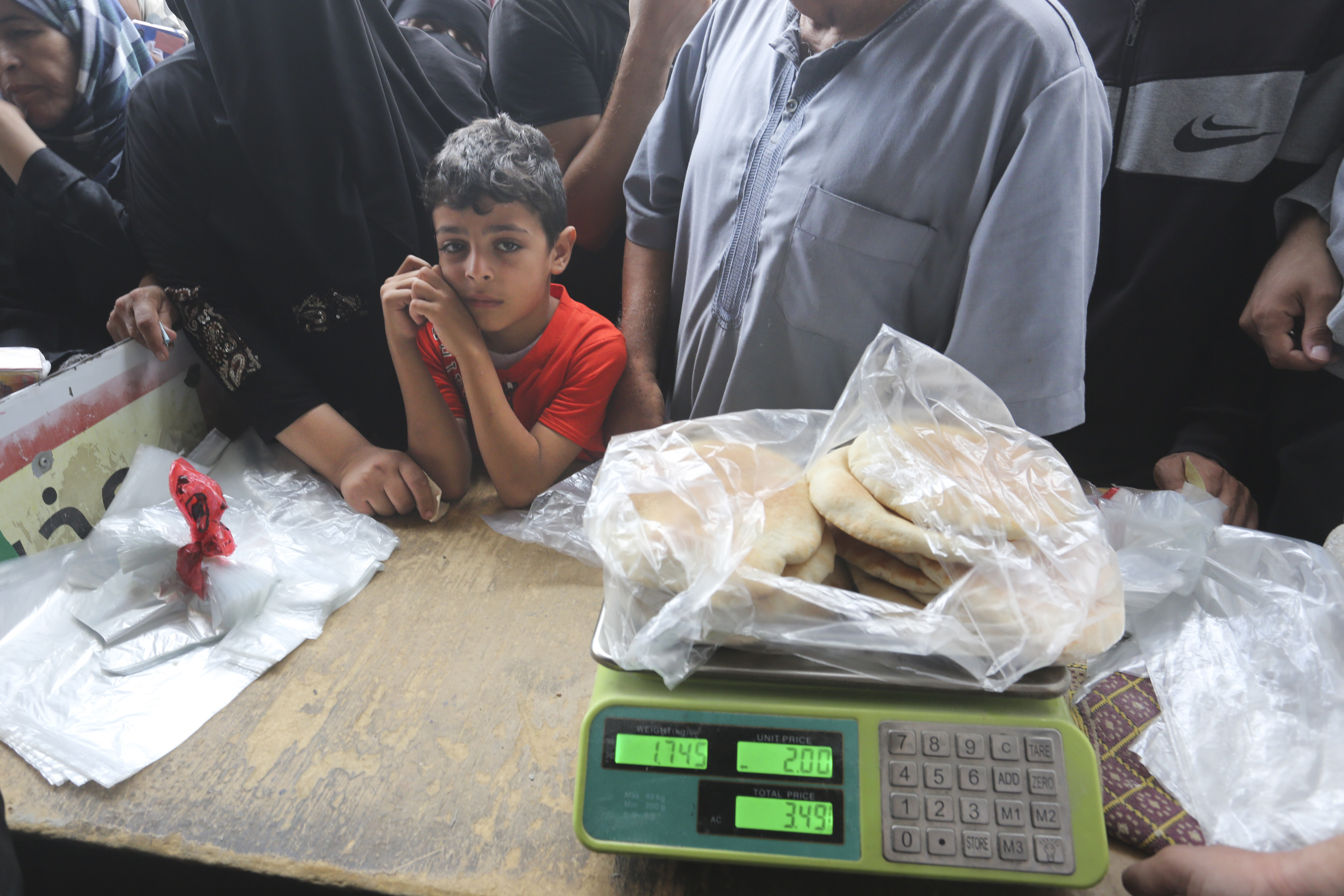 Palestinians wait to buy bread during the ongoing bombardment of the Gaza Strip in Rafah. Photo / AP