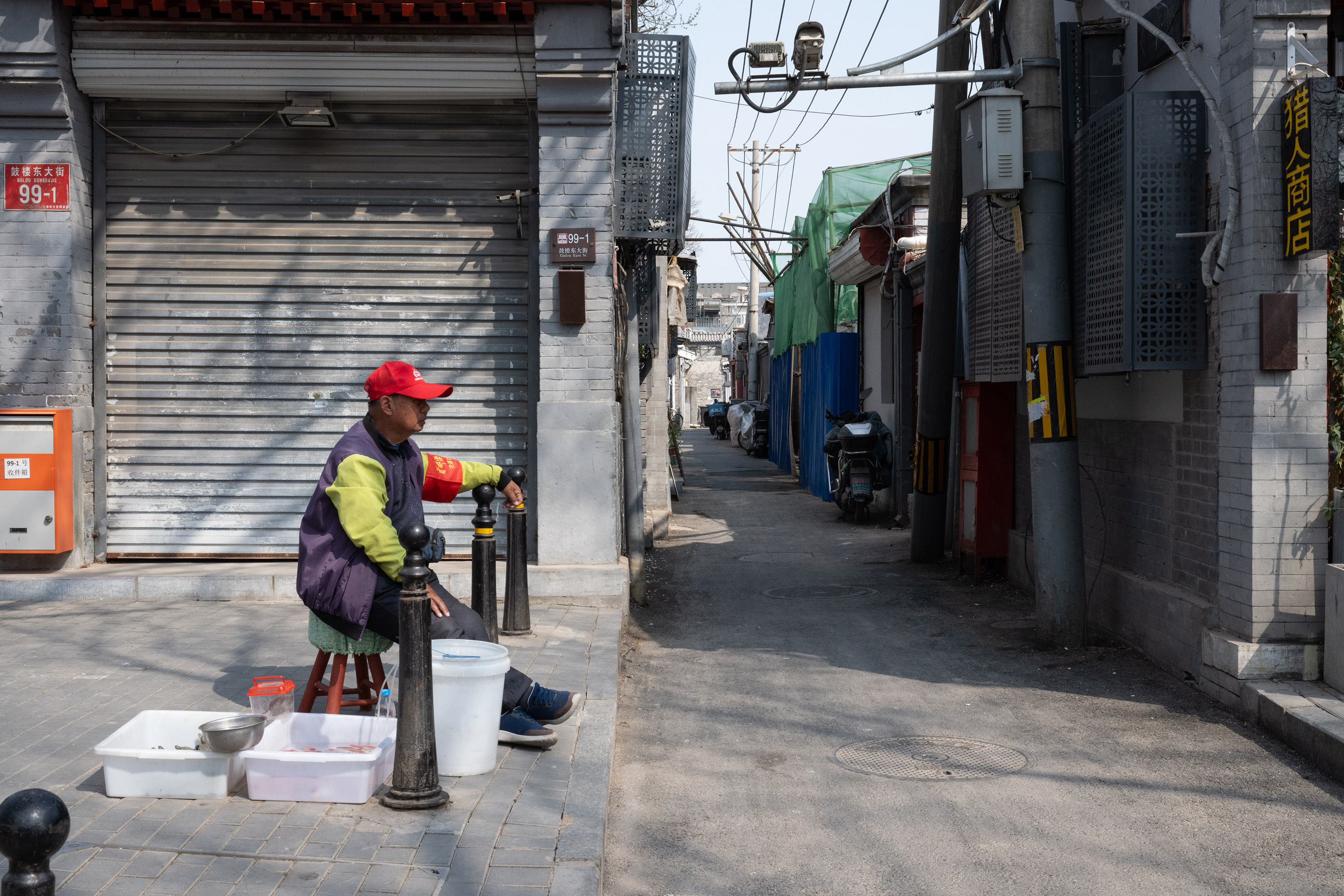 A volunteer from a neighbourhood committee keeping watch on a street while feeding goldfish. Such workers are especially visible on holidays or during major political meetings, ensuring that public order is maintained. Photo / Gilles Sabrié, The New York Times