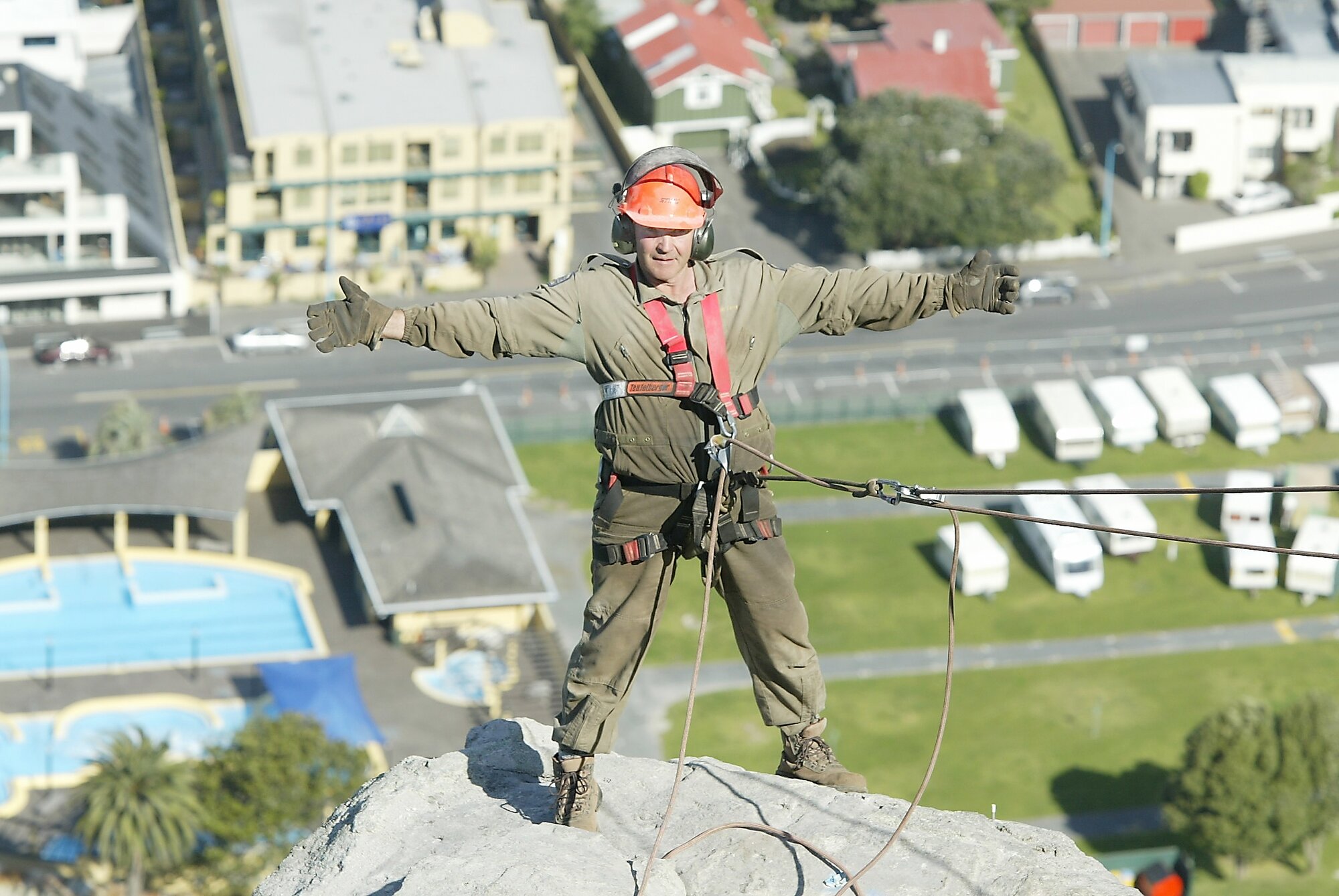 Explosives expert Bob Gray prior to the explosion on Mount Maunganui, with the campground and hot pools below. Photo / NZME