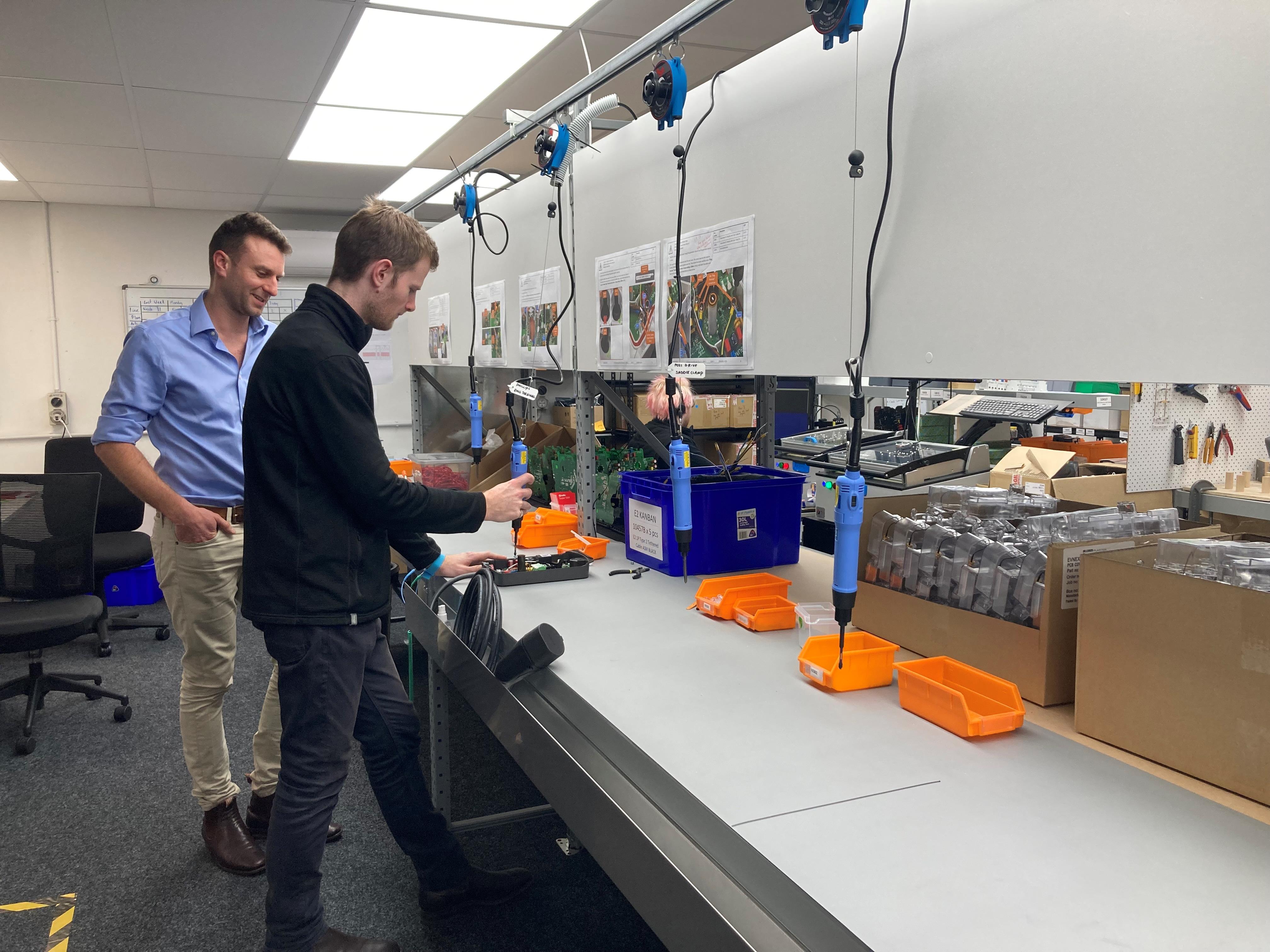 Evnex founder and CEO Ed Harvey (left) with a technician on his firm's Christchurch assembly line.