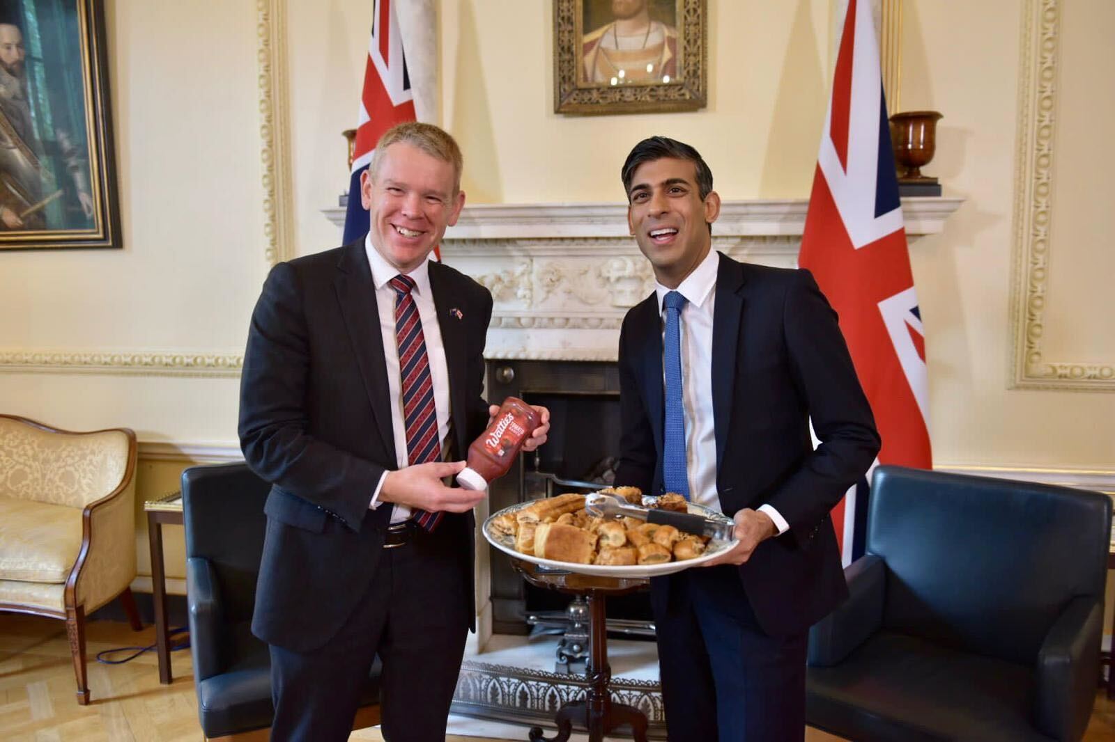 British Prime Minister Rishi Sunak, right, shows off sausage rolls as New Zealand Prime Minister Chris Hipkins brings the tomato sauce at 10 Downing St in London. Photo / Jenni Mortimer