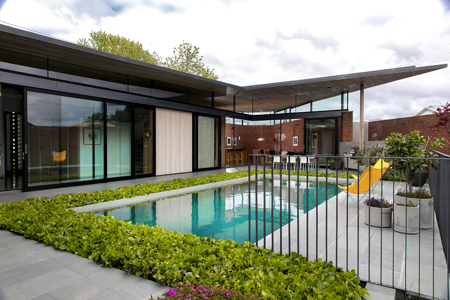 Rather than cutting off access to the pool with a potentially unattractive safety fence, it’s fringed by a green moat of griselinia, transforming the pool itself into a water feature that can be appreciated from almost every room. Photo / Babiche Martens