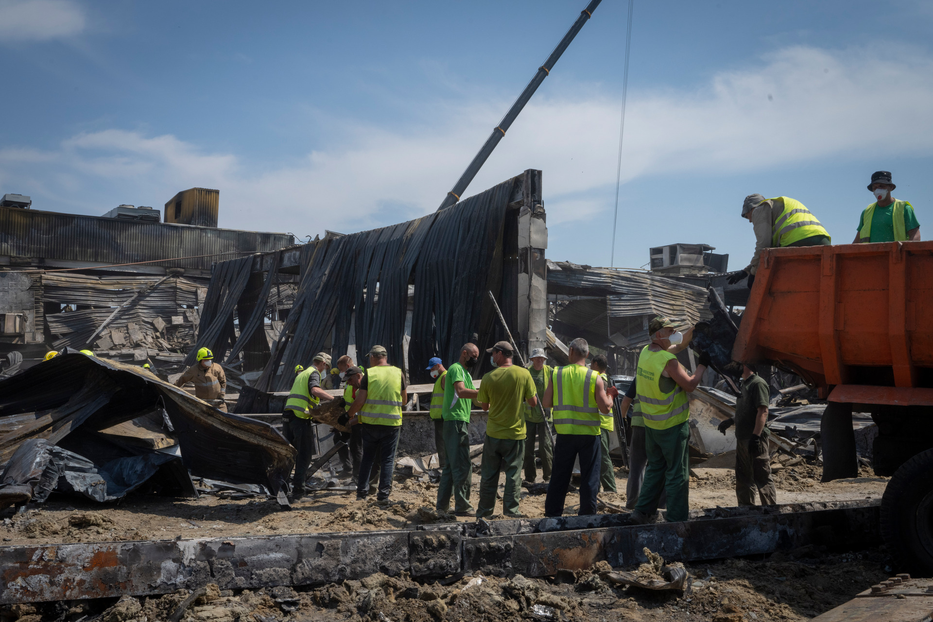 Workers clear debris at a shopping centre damaged in a Russian rocket attack in Kremenchuk, Ukraine. Photo / Efrem Lukatsky, AP