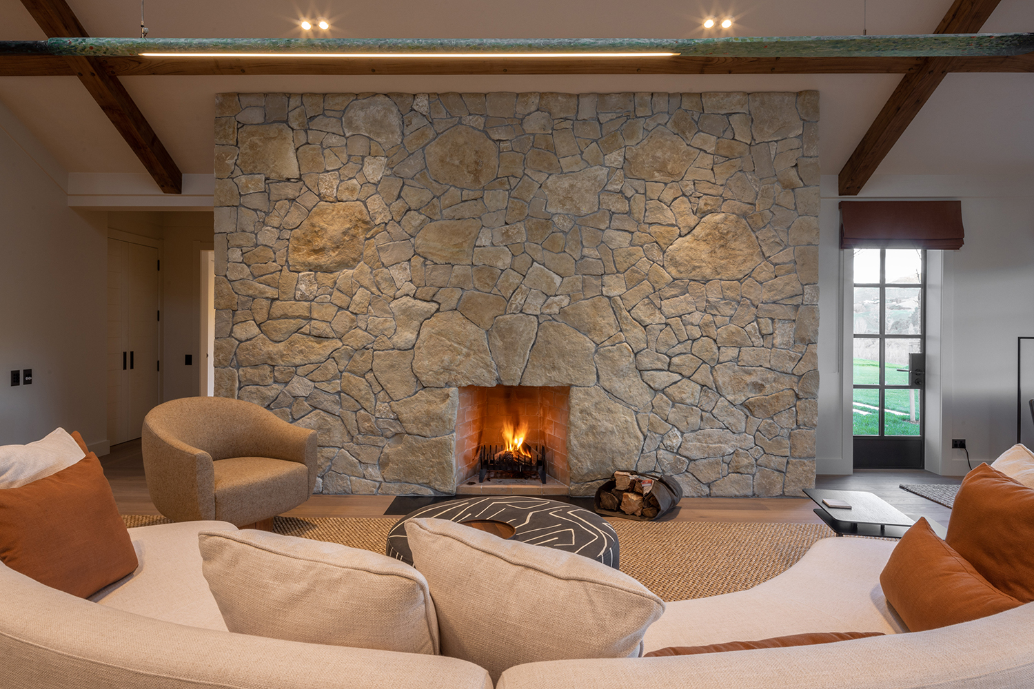 The limestone fireplace and handpainted oar pendant light by Leanne Culy at Euchre Lodge. Photo / Supplied