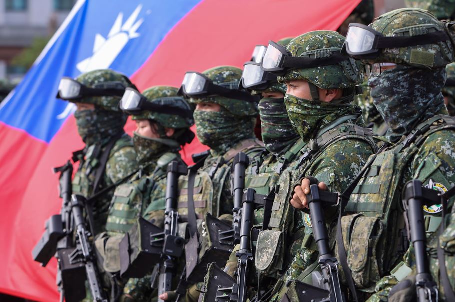 Soldiers pose for group photos with a Taiwan flag after a preparedness enhancement drill simulating the defence against Beijing’s military intrusions. Photo / AP