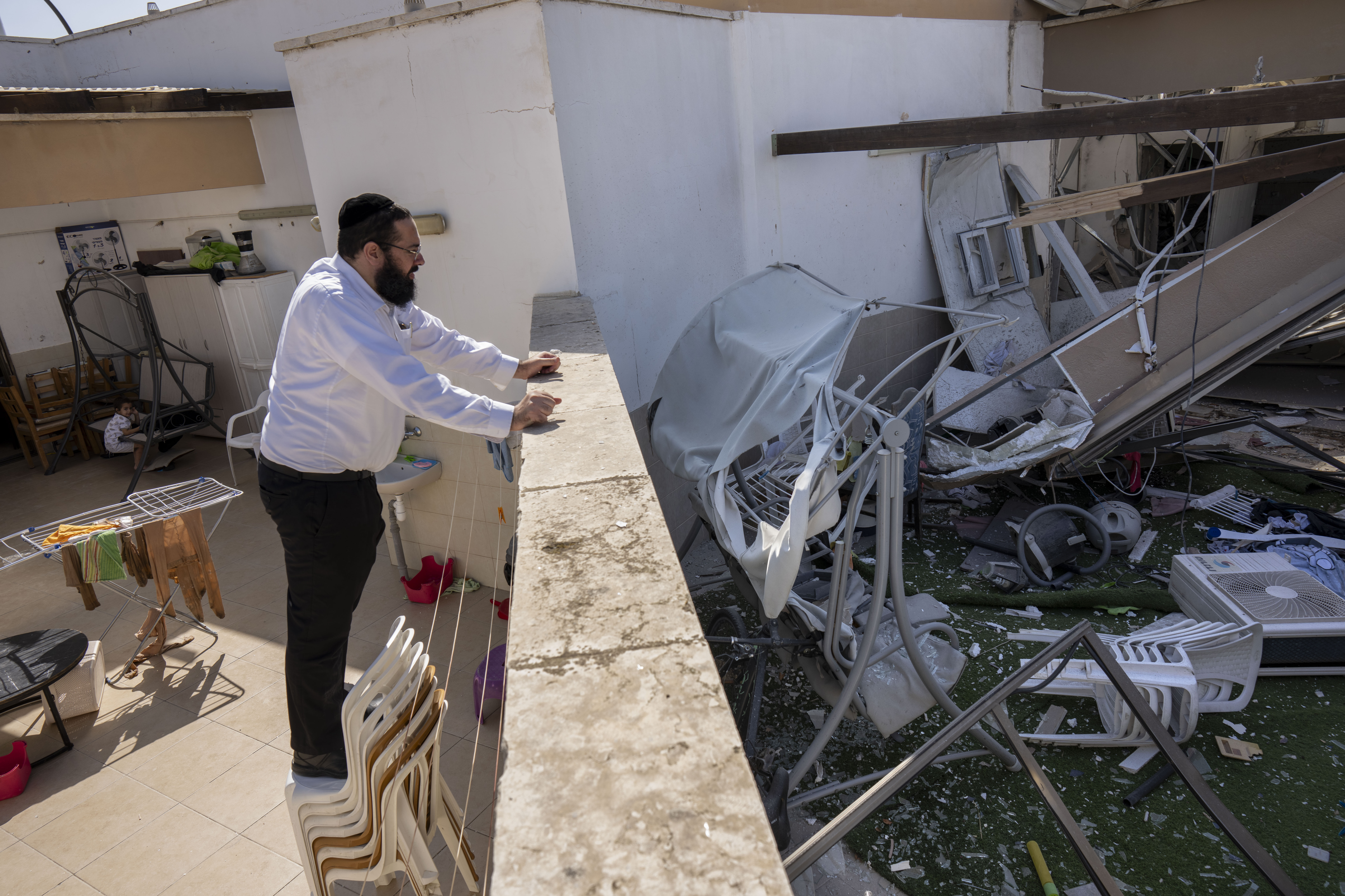 An Israeli man checks the damage of his neighbour's house after it was hit by a rocket fired from the Gaza Strip in Netivot, Israel. Photo / AP