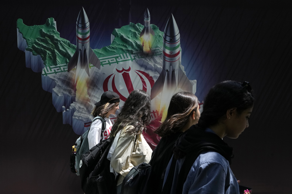 Iranian women walk past a banner showing missiles being launched from the Iranian map in northern Tehran on April 19. Iran fired air defences at an airbase and a nuclear site near the city of Isfahan after spotting drones early on Friday morning, raising fears of a Israeli retaliation for Tehran's drone and missile assault on the country. Photo / AP