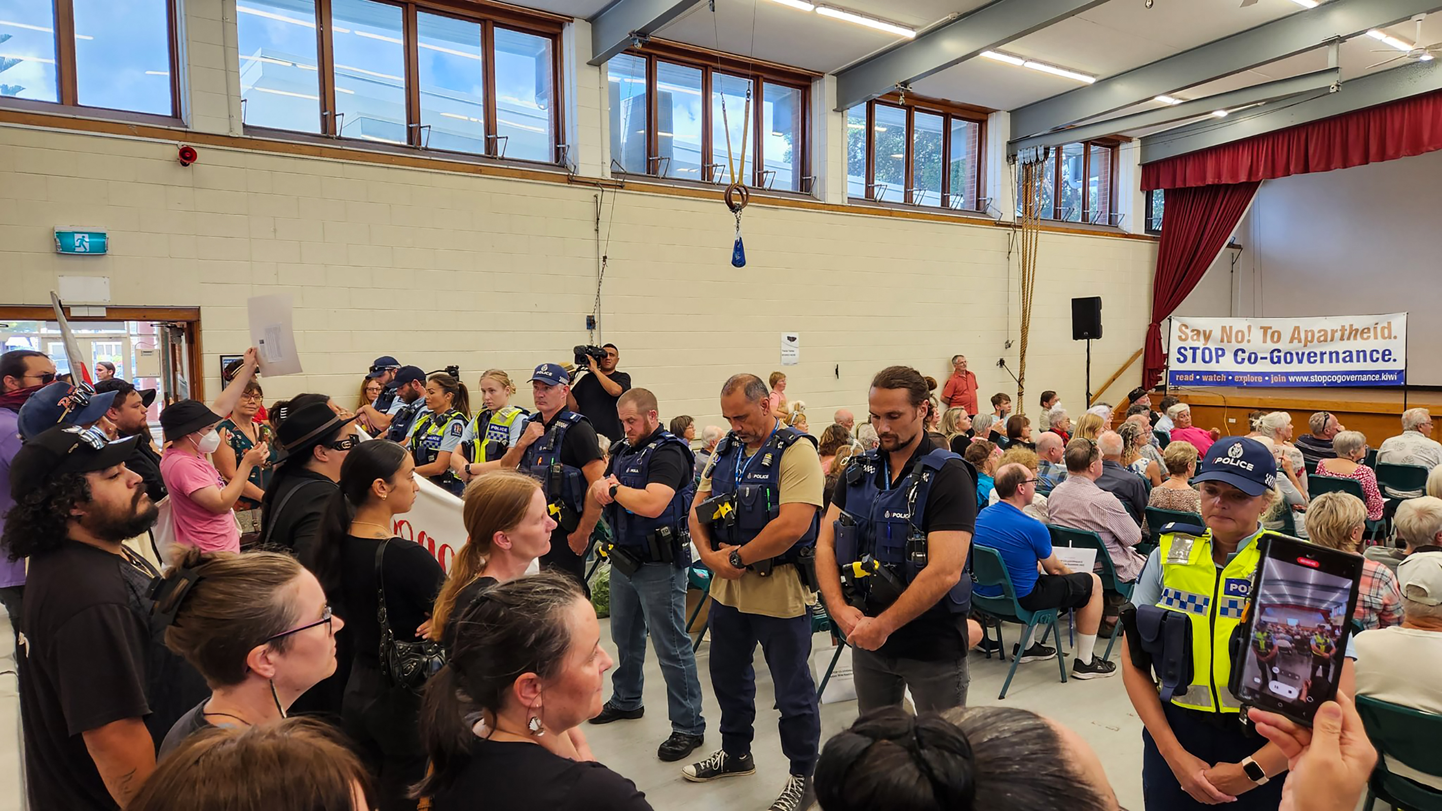 Police form a line to separate attendees from protesters at a Stop Co-Governance meeting in Orewa in March 2023.  Photo / Mikaela Matenga

