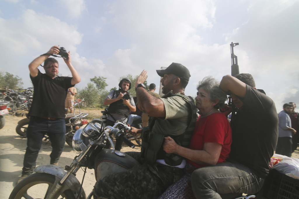 Palestinians transport a captured Israeli civilian, centre, from Kibbutz Kfar Azza into the Gaza Strip. Photo / AP