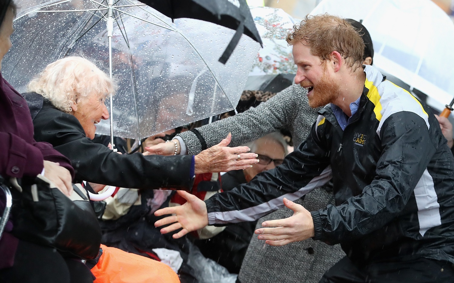 Prince Harry hugged Daphne Dunne during a walkabout in the torrential rain ahead of the Invictus Games launch in Sydney, 2017. Photo / Getty Images