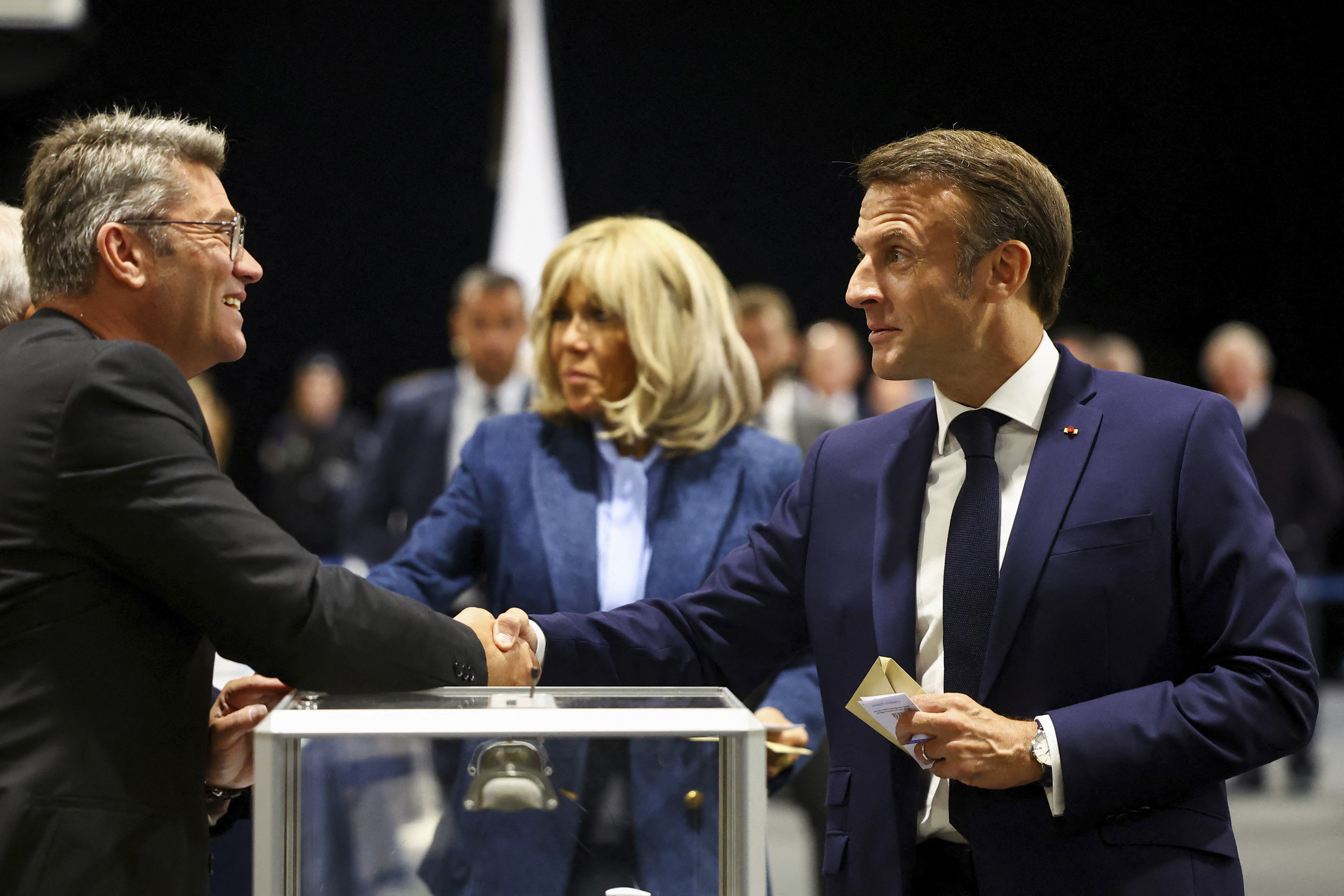 French President Emmanuel Macron, right, shakes hands with a polling station official during the European election on  Sunday, June 9 in Le Touquet-Paris-Plage, northern France. Photo / AP