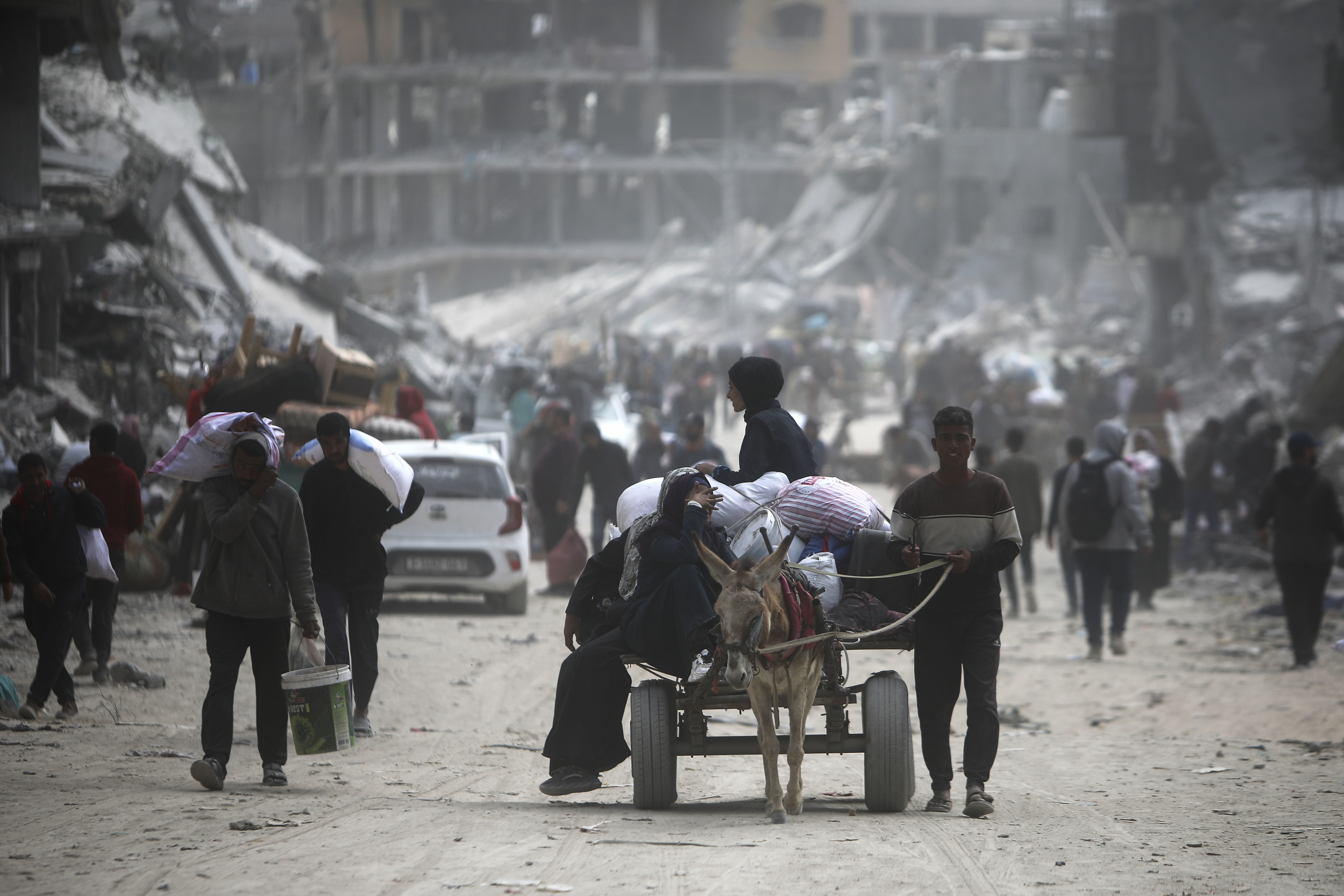 Palestinians carry their belongings after visiting their houses, destroyed in the Israeli offensive on Khan Younis, Gaza Strip. Photo / AP