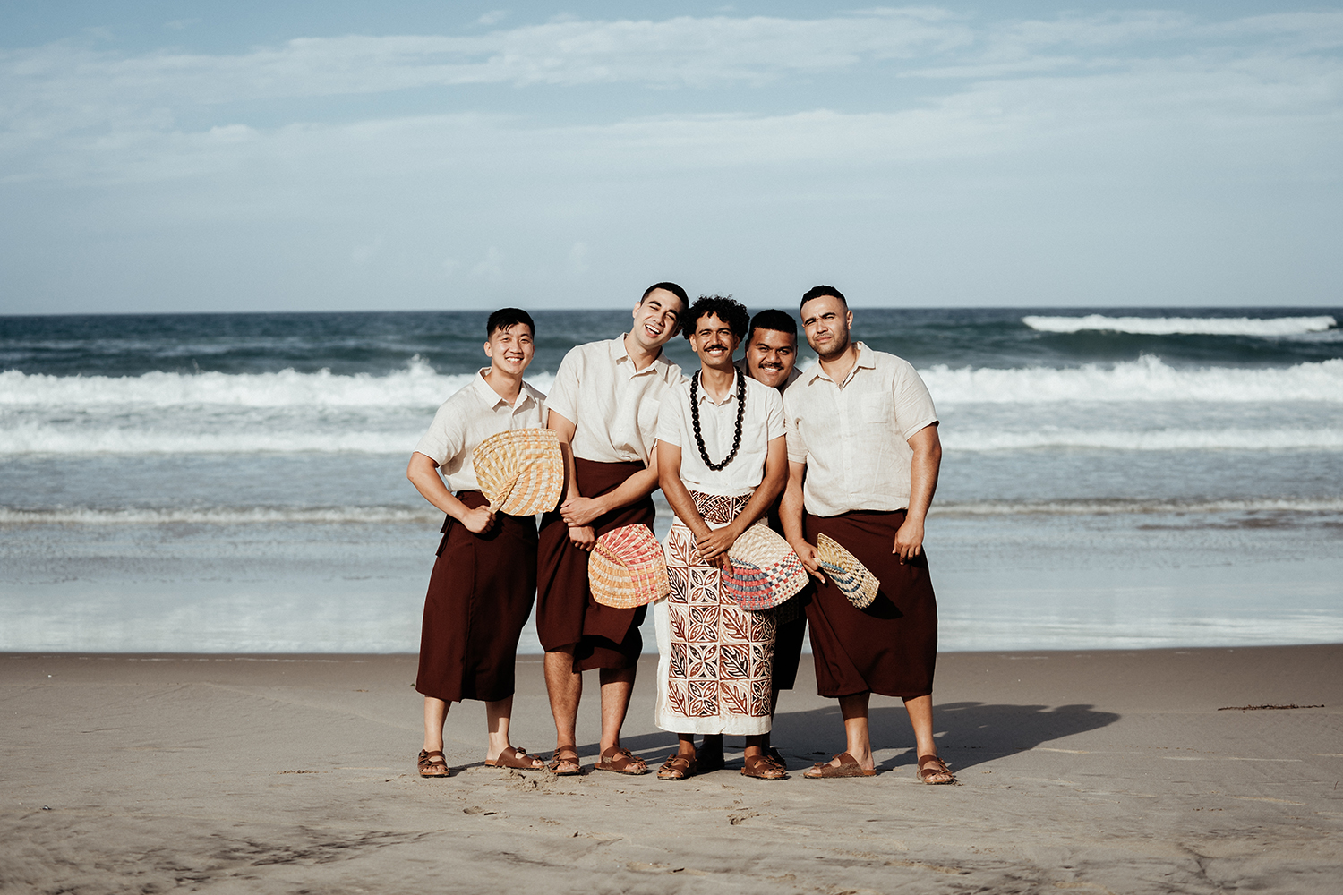 Connor and his groomsmen wore i’e faitaga with matching linen shirts and carried handwoven ili. Photo / Geoffery Matautia and Hele Ikimotu.