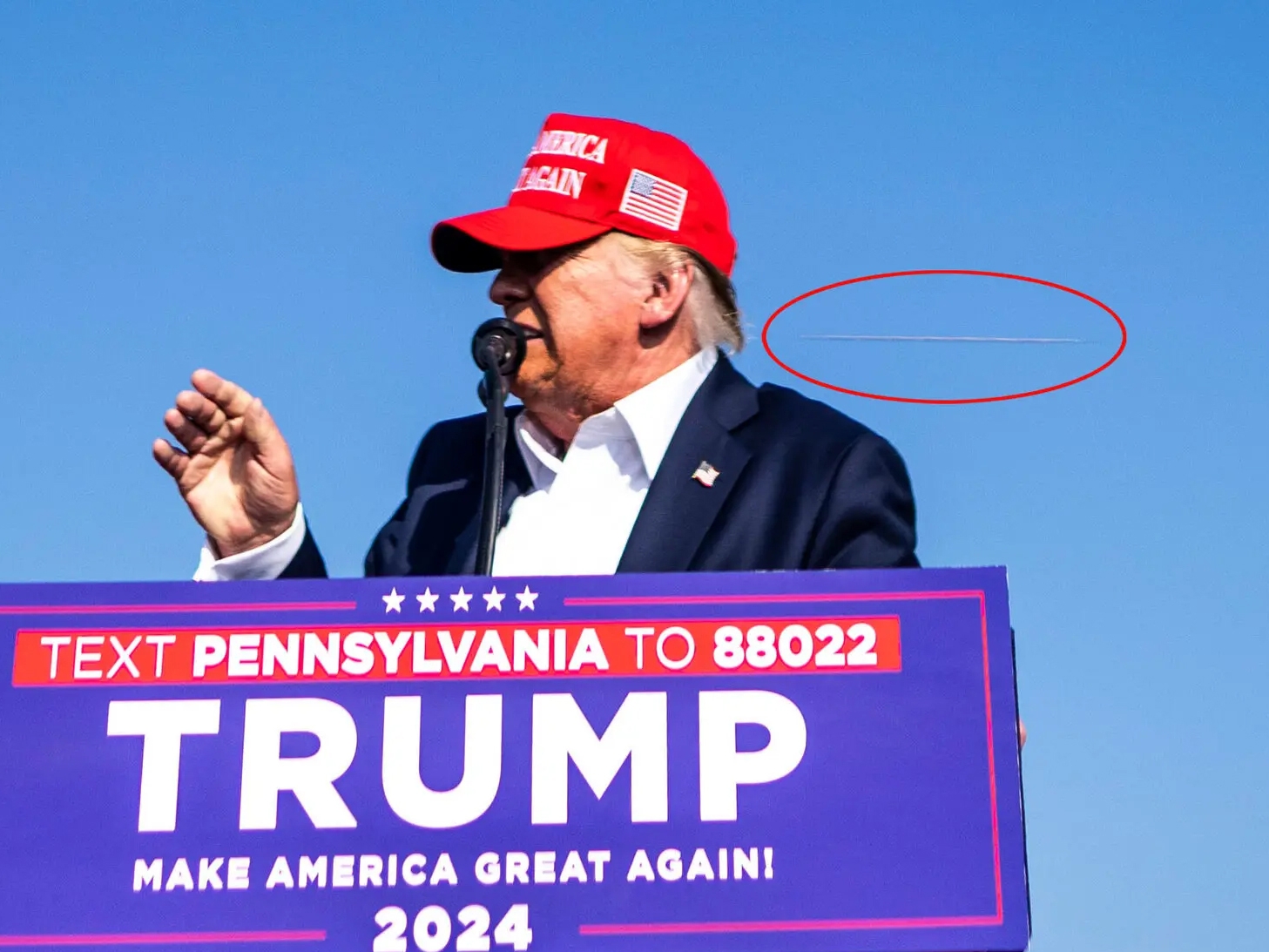 An annotated photo showing what appears to be a projectile passing by Trump. Photo / Doug Mills, The New York Times