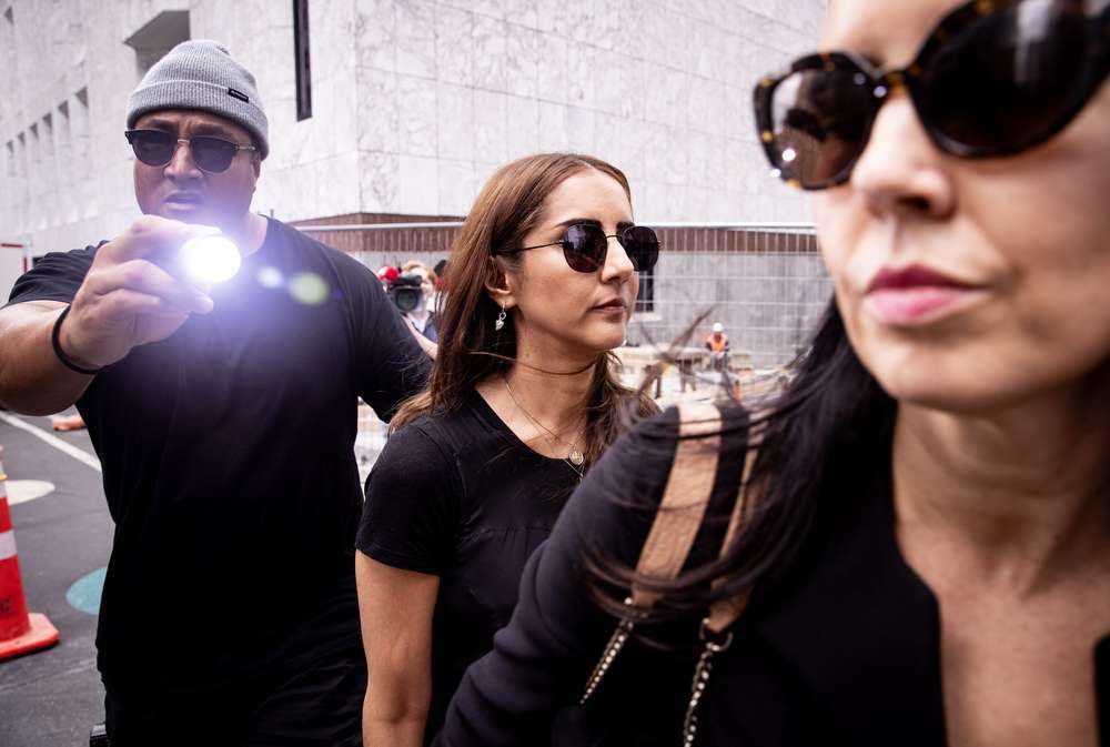 A man understood to be acting as security for Golriz Ghahraman shines a torch into photographers' cameras after an Auckland District Court hearing. Photo / Dean Purcell